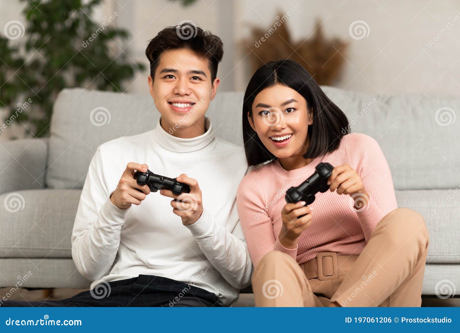 Happy boyfriend and girlfriend playing video games and holding