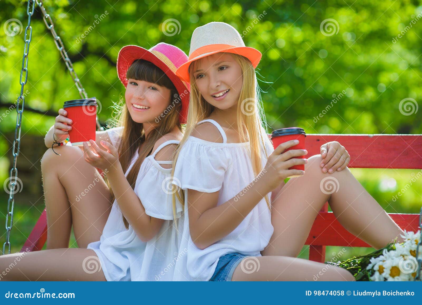 Joyful Girlfriends Having Fun On Swing Outdoor Friendship Concept