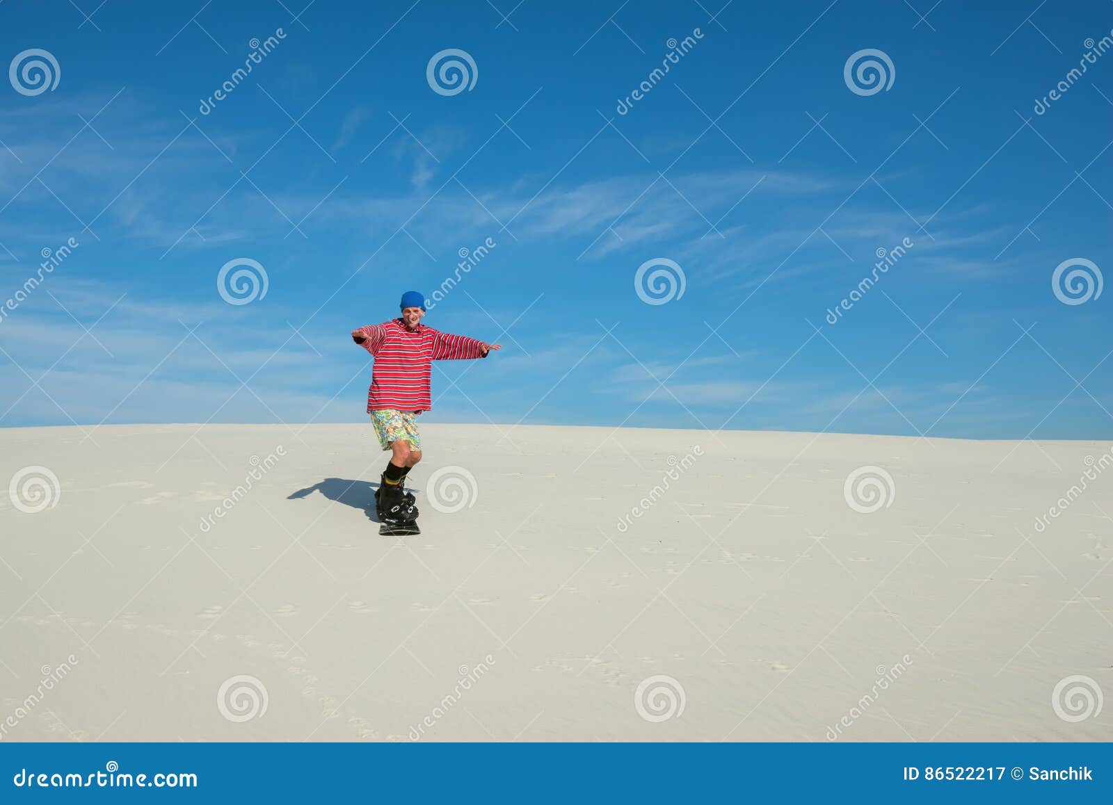 Joyful Man Slides Down on a Snowboard on the Sand Dune Stock Image ...