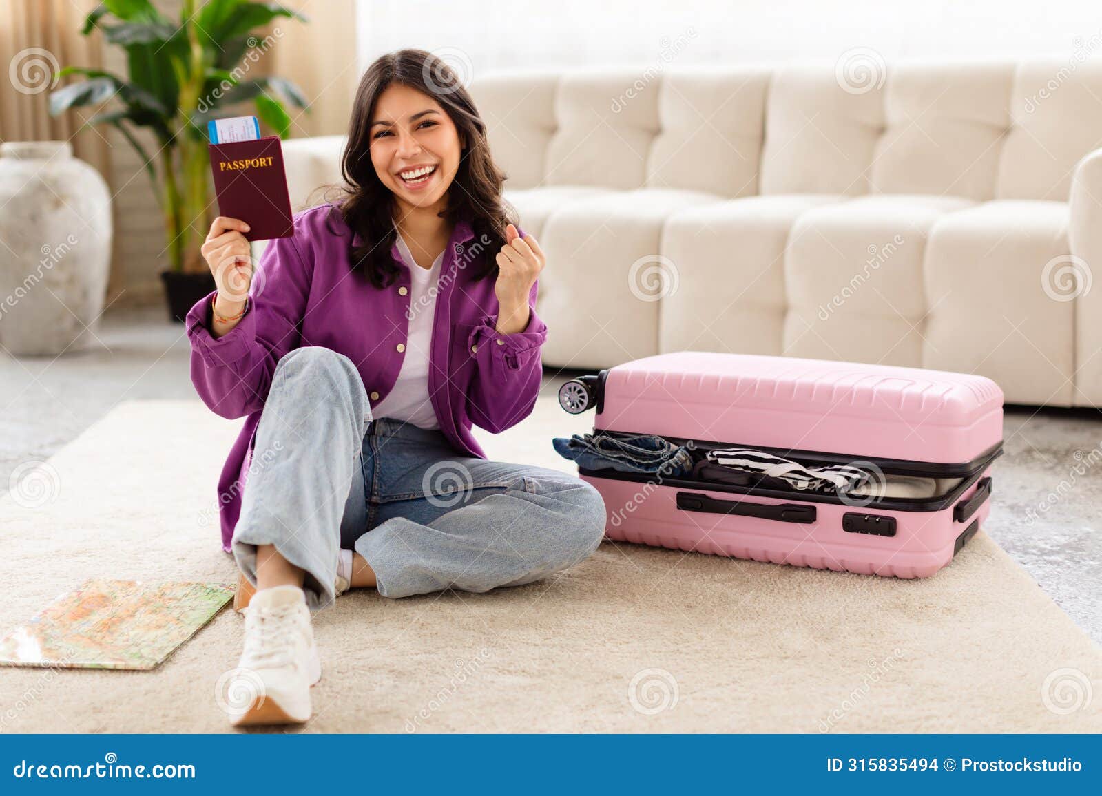joyful woman holding passport with suitcase closed