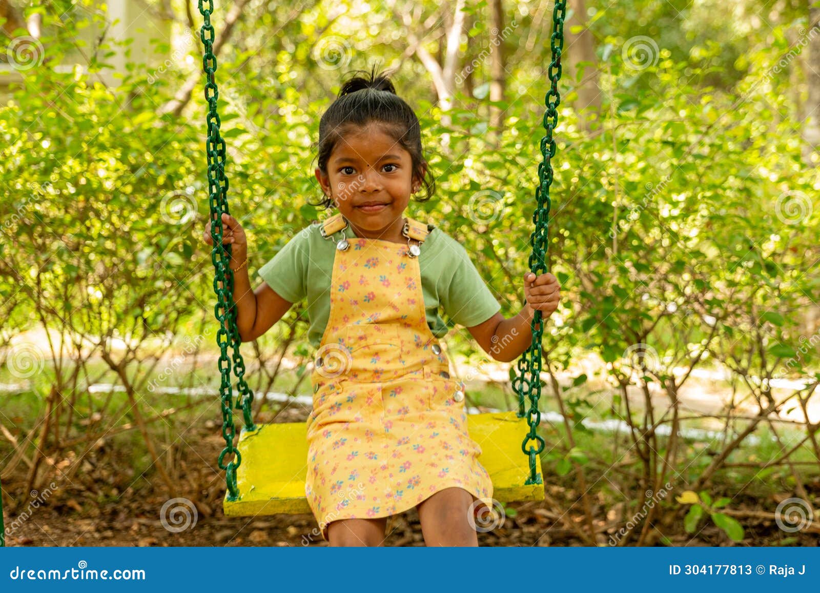 joyful young girl swinging in a park chair