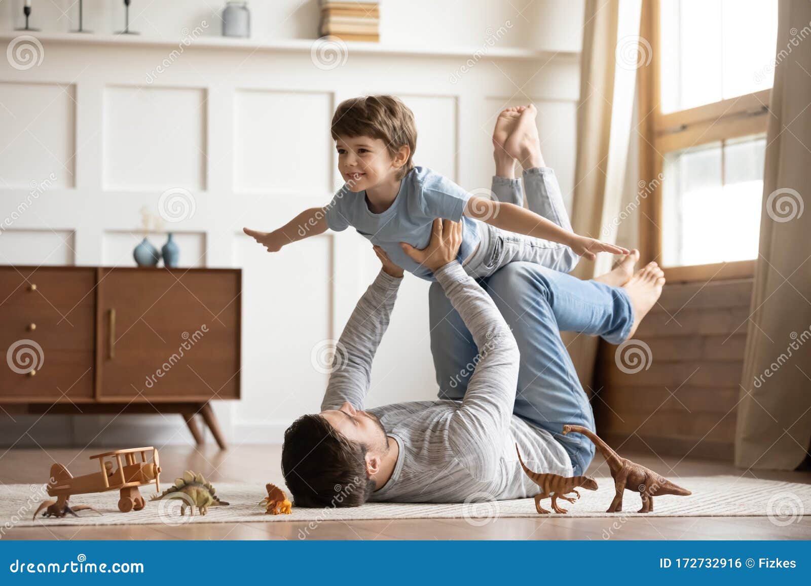 joyful young man father lifting excited happy little son.