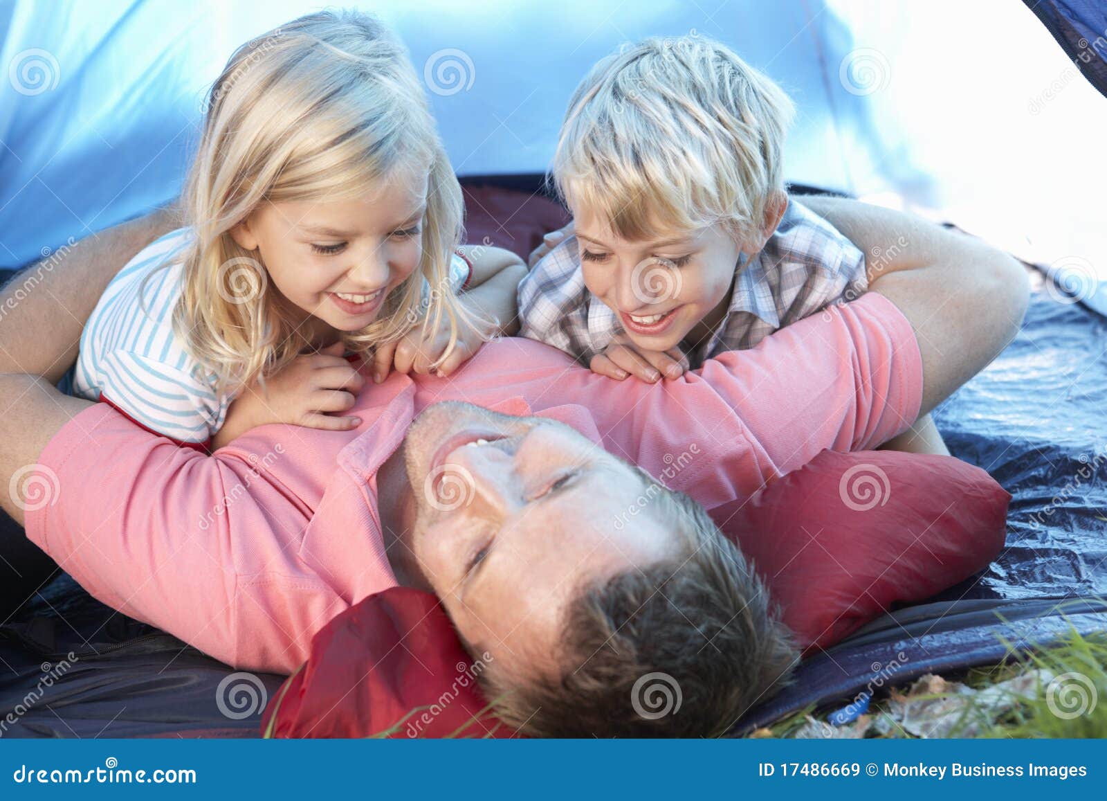 Juegos jovenes del padre con los niños en tienda. El padre joven juega con los niños en la sonrisa de la tienda