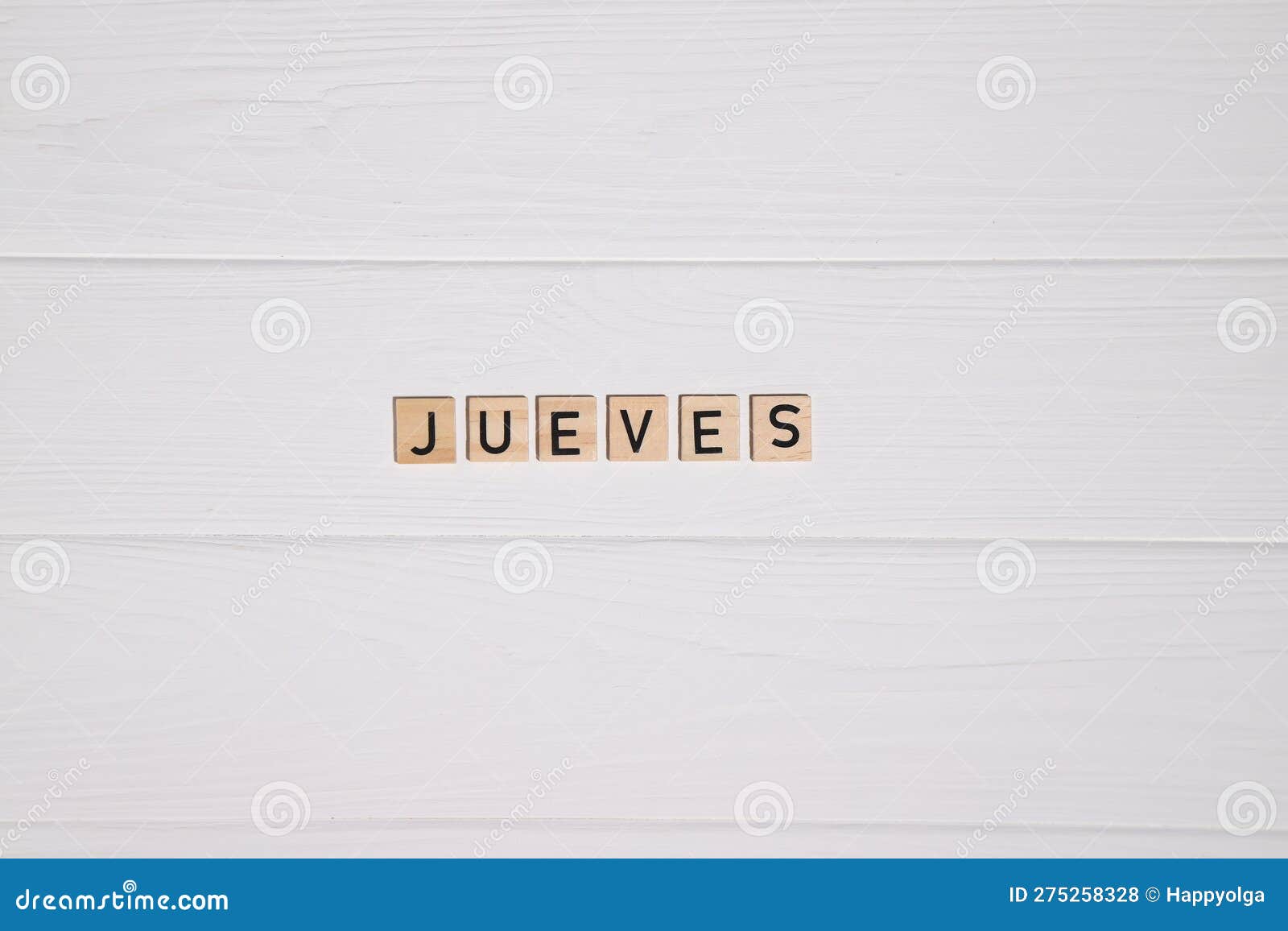 jueves week day name on white wooden background