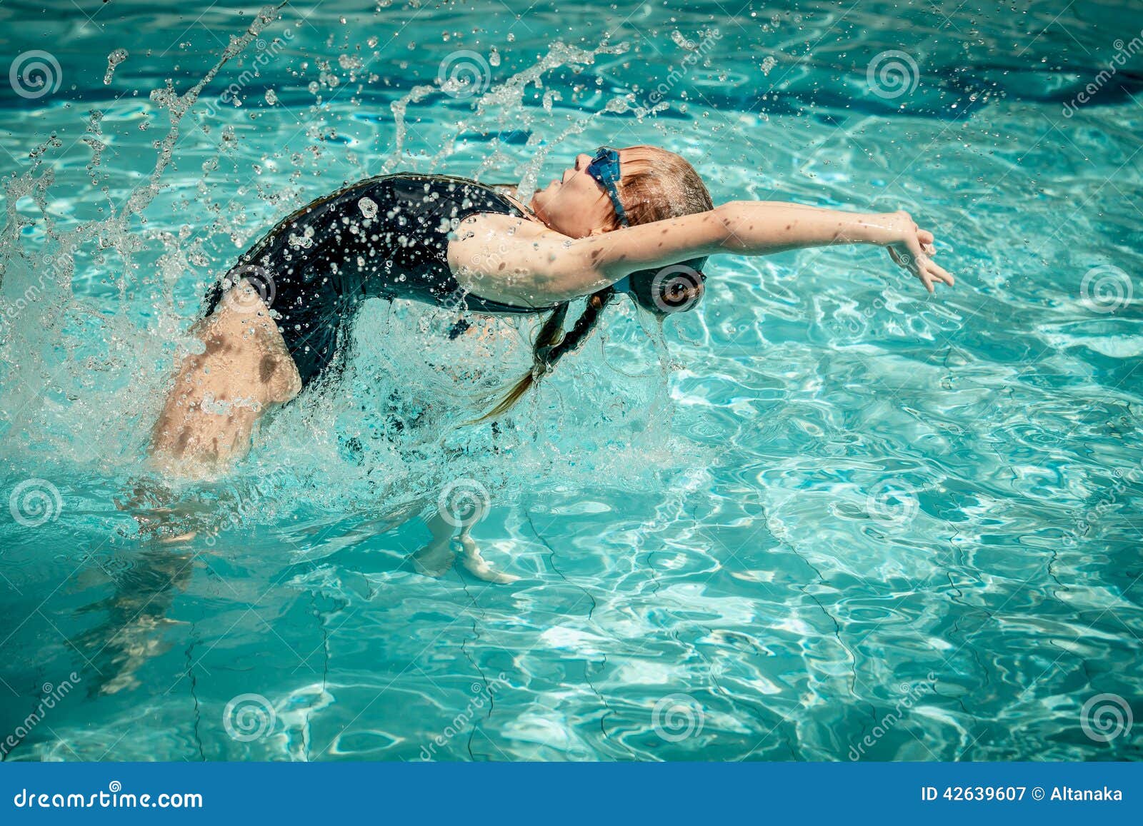 Jugendlich Mädchen, das in den Swimmingpool springt. Jugendlich Mädchen, das in den Swimmingpool zur Tageszeit springt