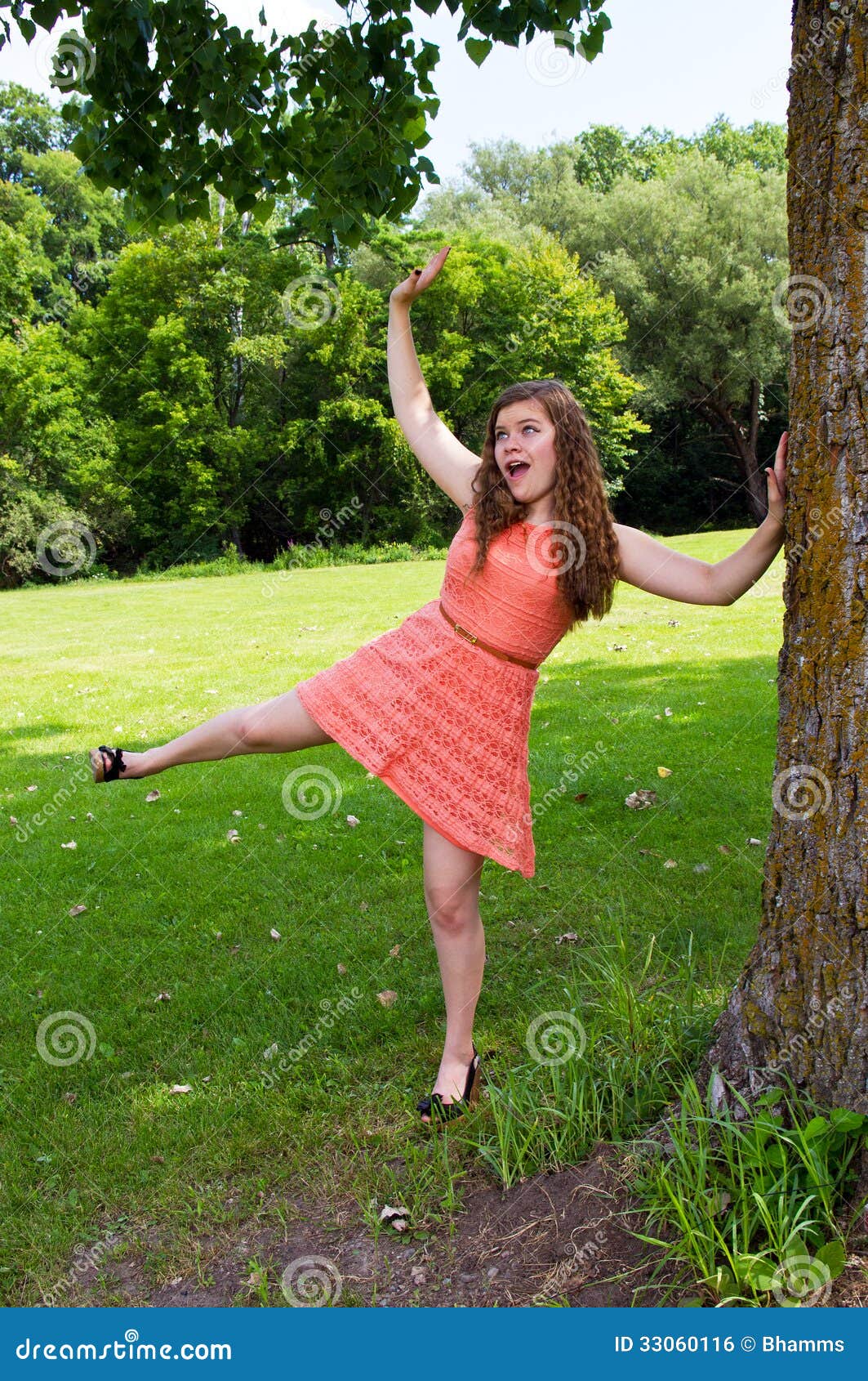 Jugendlich Mädchen draußen an einem NY-Park. Jugendlich Mädchen in einem Park mit orange Kleid