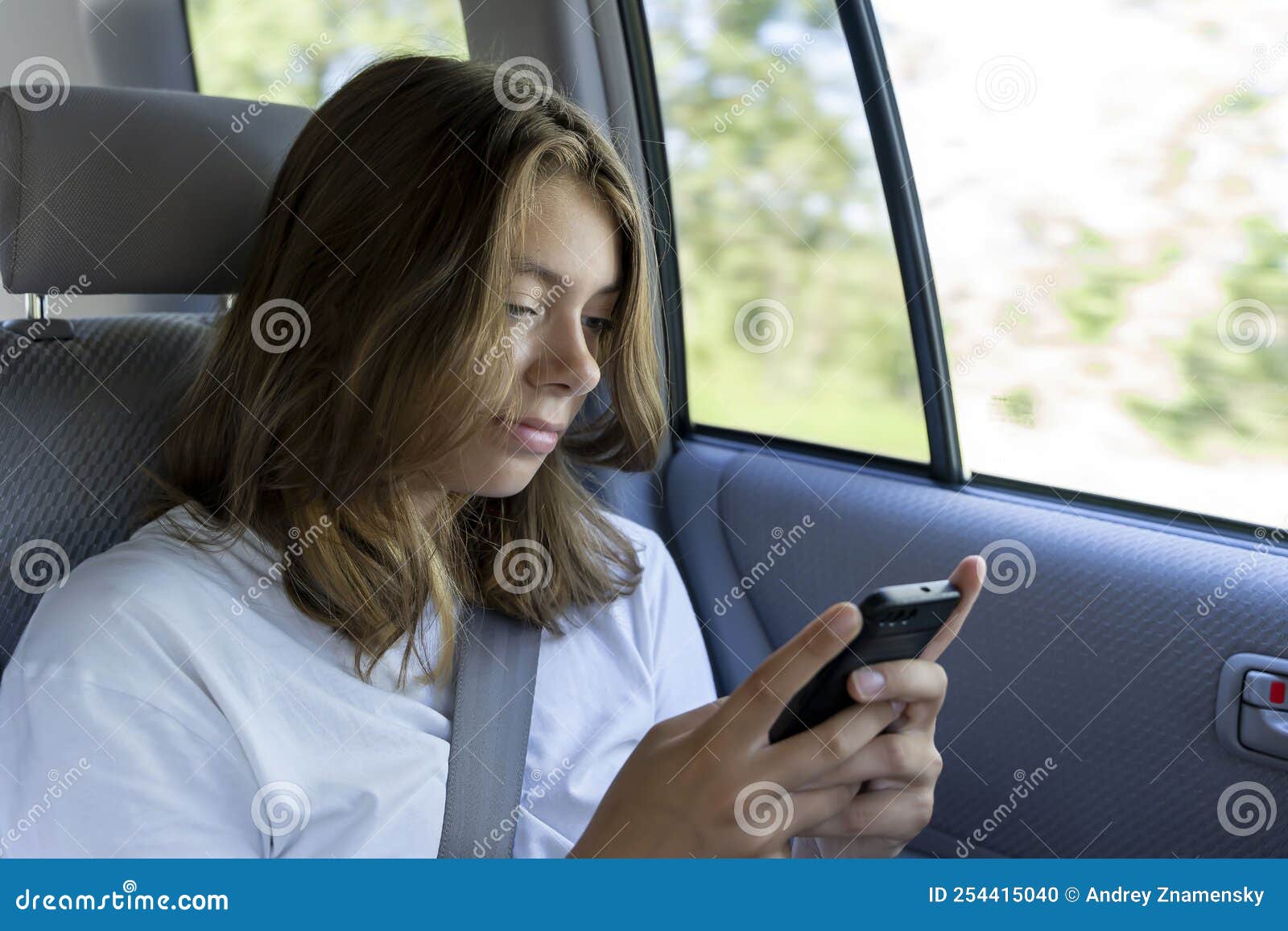 Jugendliche Fahren Auf Der Rückbank Eines Autos Und Benutzen Smartphone  Stockfoto - Bild von betrieb, kaukasisch: 254415040