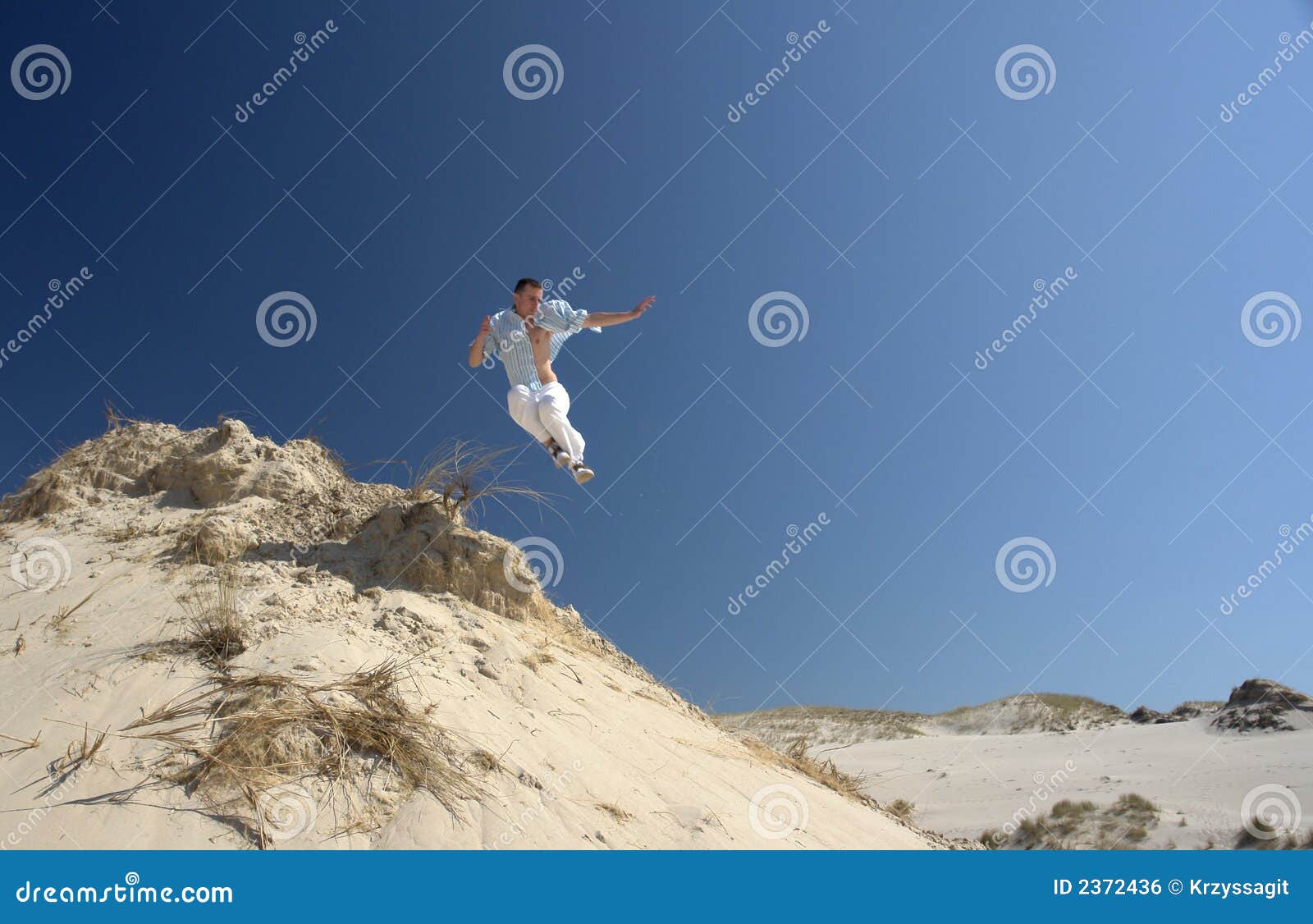 Jump! stock photo. Image of dune, jumping, blue, energetic 2372436