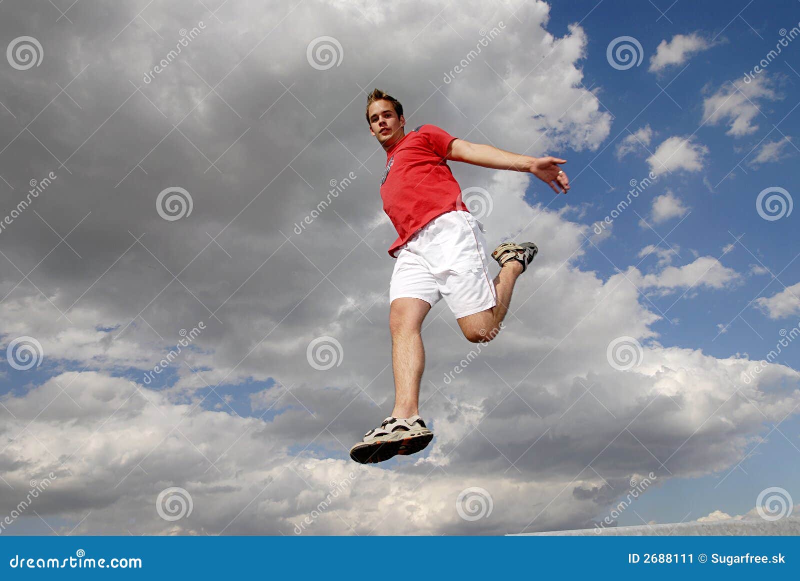 Jumpin . Young man happily jumping against blue sky.