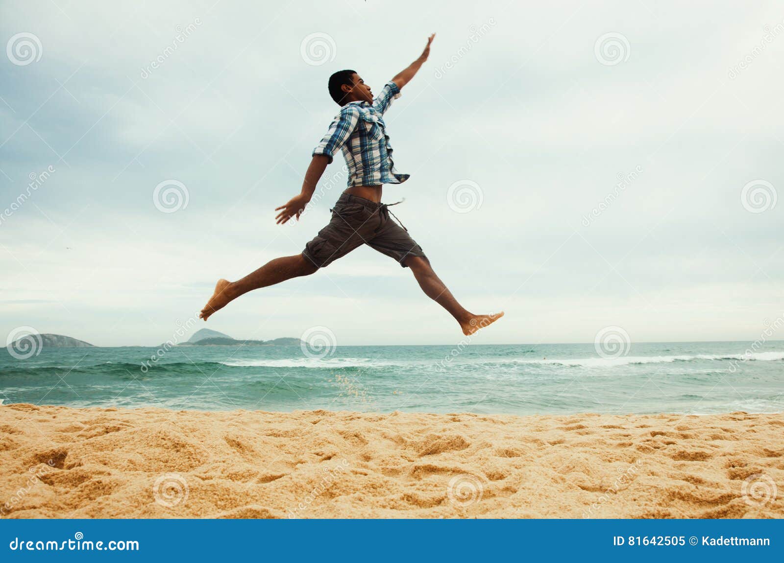 Jumping latin guy at beach stock image. Image of happiness 81642505