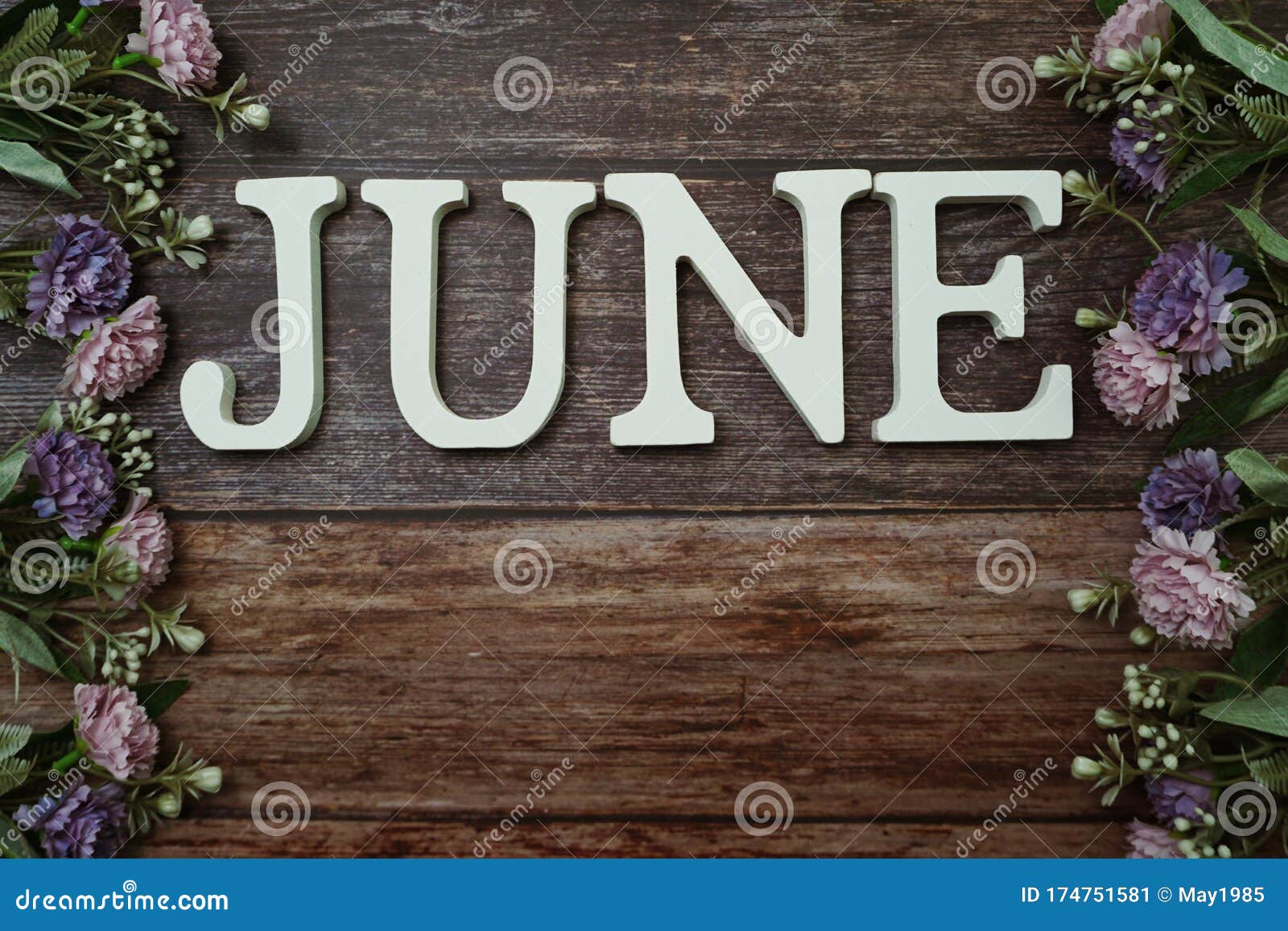 june alphabet letters with flower decoration on wooden background