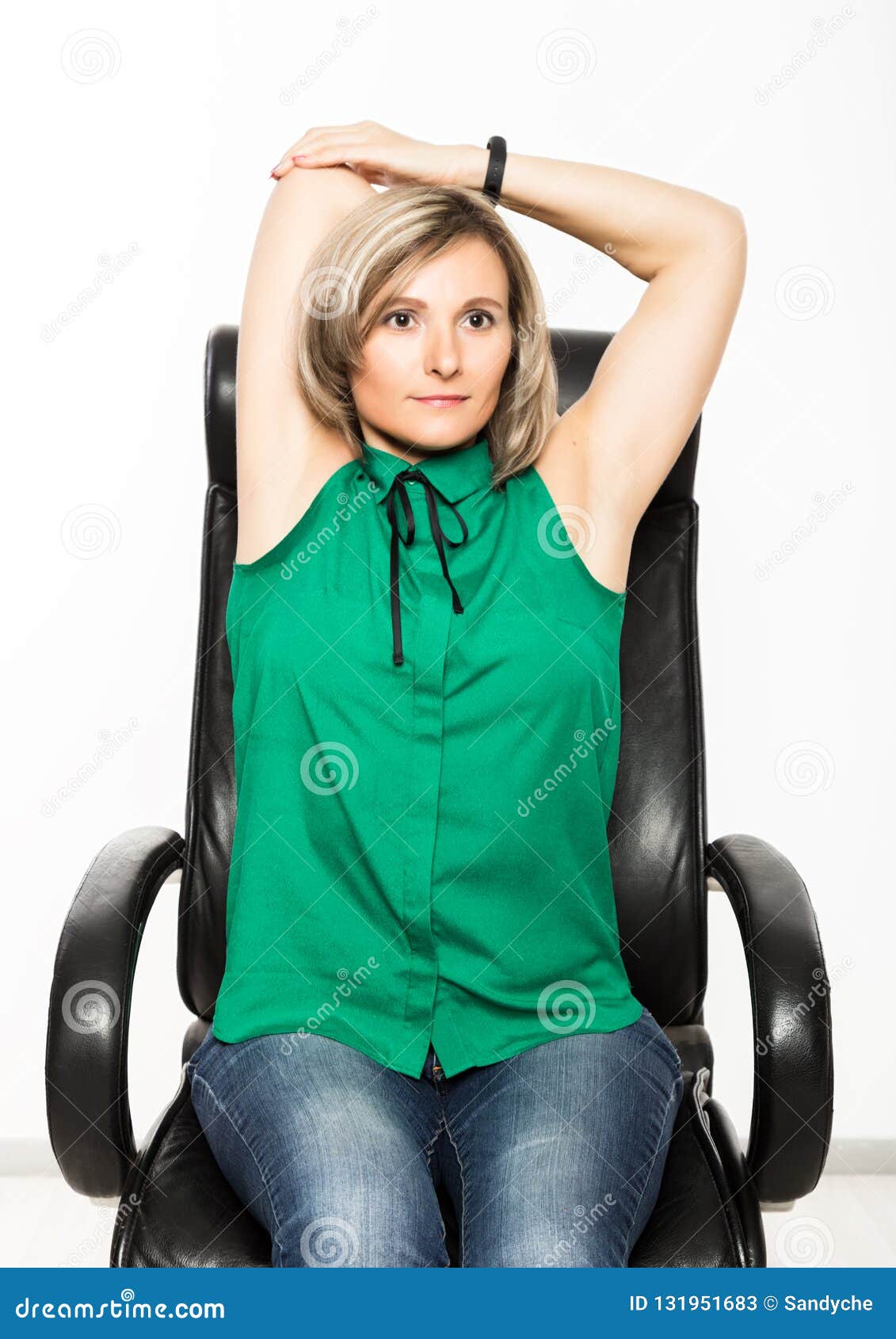 Junge Geschäftsfrau, die auf dem Stuhl tut Eignungsübung am Arbeitsplatz sitzt