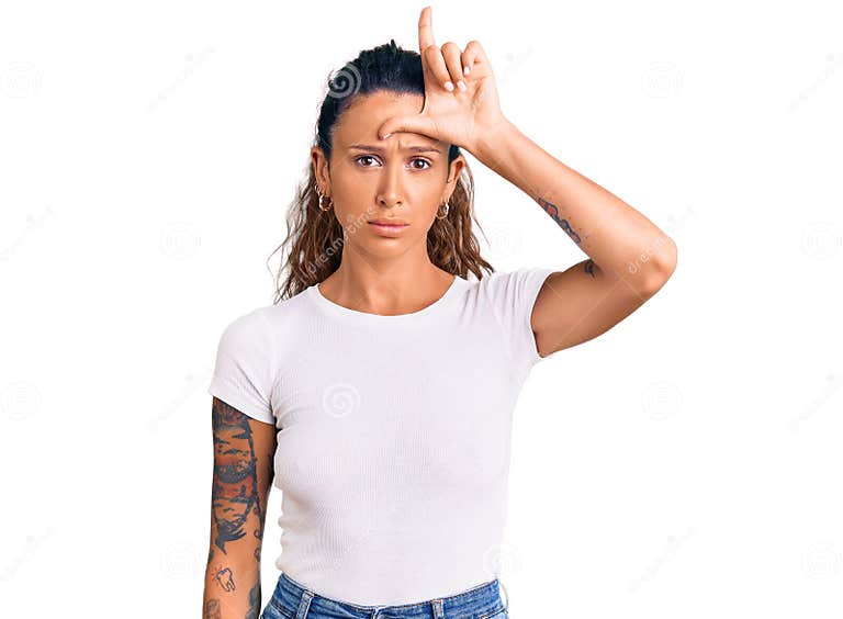 junge-hispanic-frau-mit-tattoo-tragen-casual-white-shirt-machen-lustig-von-menschen-fingern-auf-der-stirn-tun-loser-geste-spotten-215786969.jpg