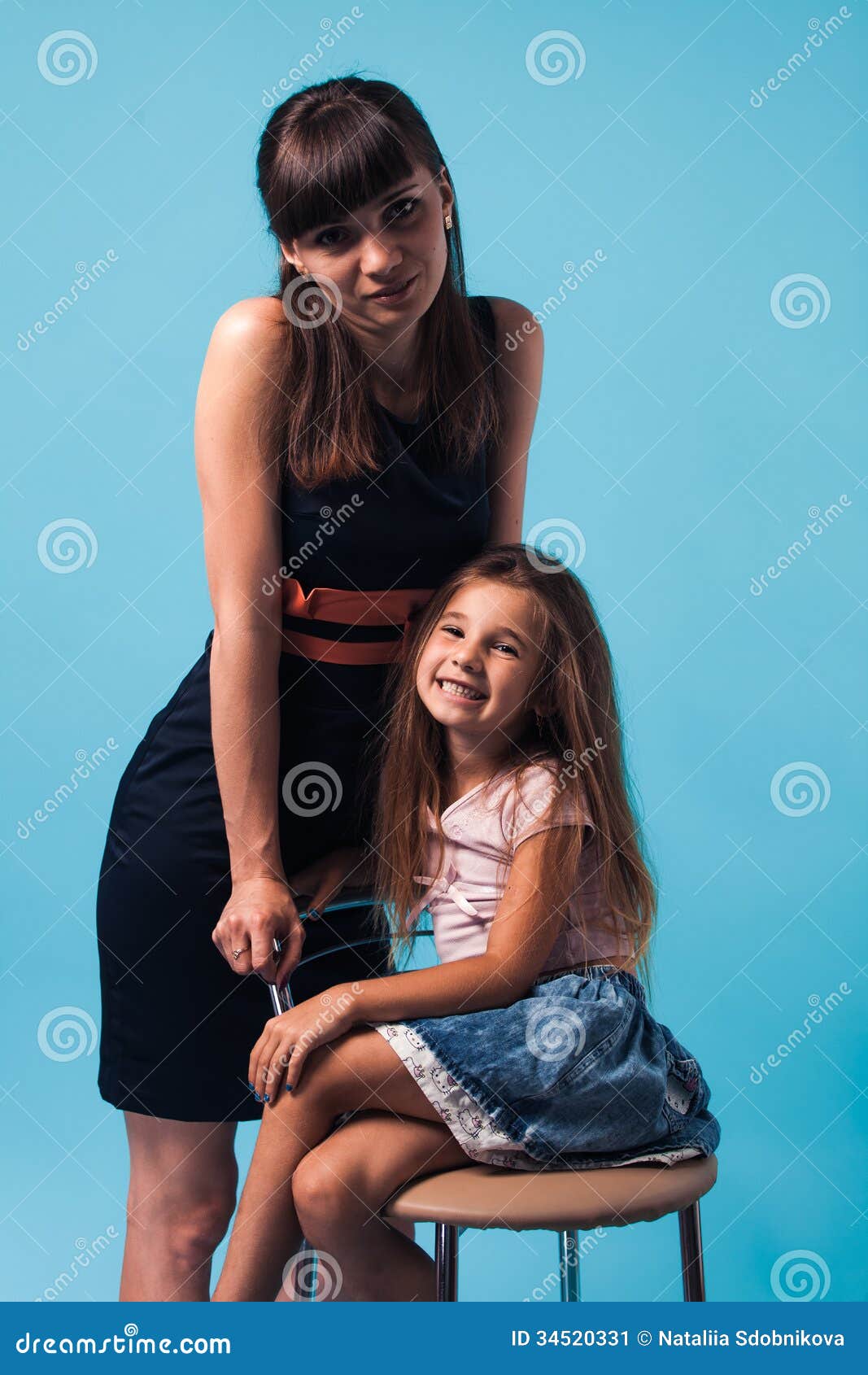 Junge Mutter mit Tochter auf blauem Hintergrund