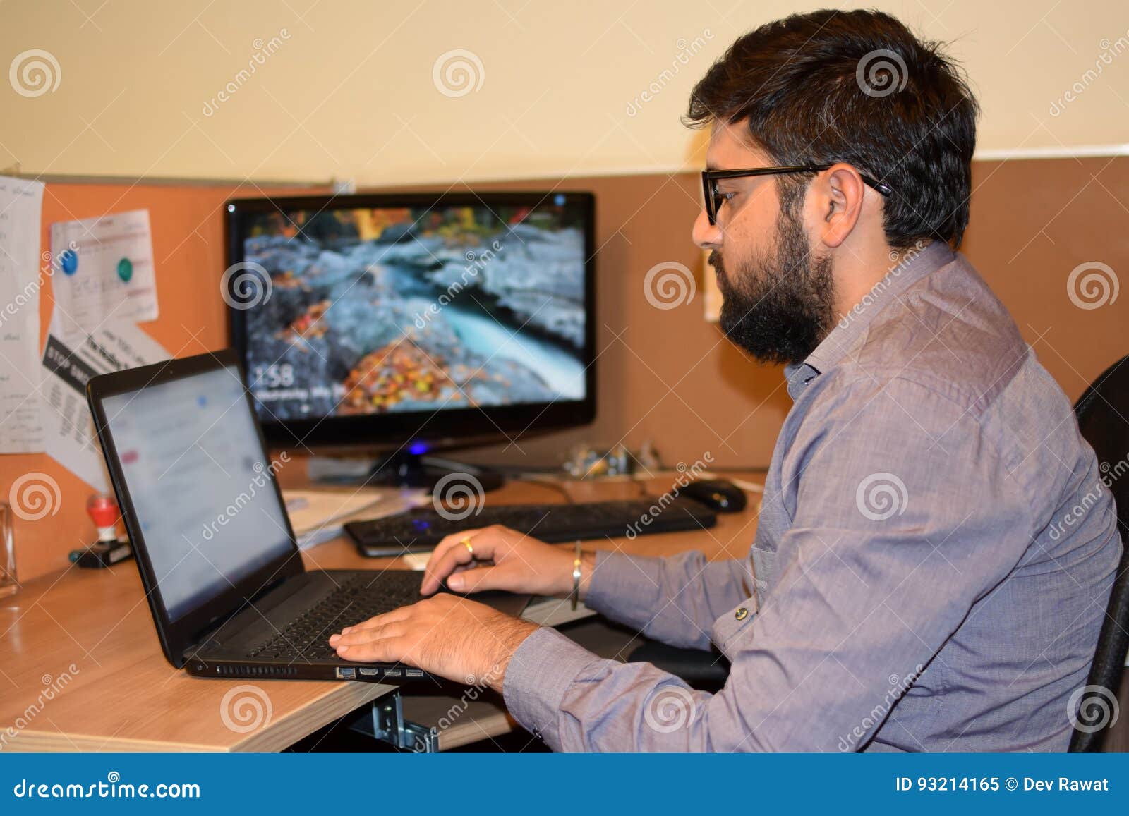 Junger Angestellter, der an Laptop während der Büroarbeitszeit im Büro arbeitet. Angestellter, der im Büro, Geschäftsmann arbeitet an Laptop arbeitet