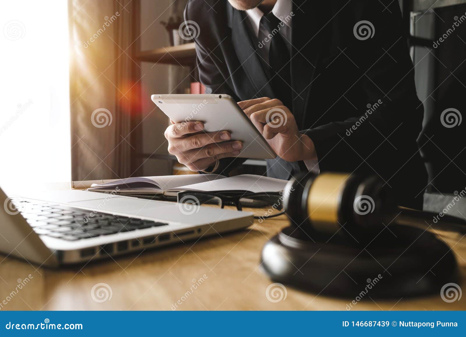 male lawyer in the office with brass scale on wooden table. justice and law concept in morning light