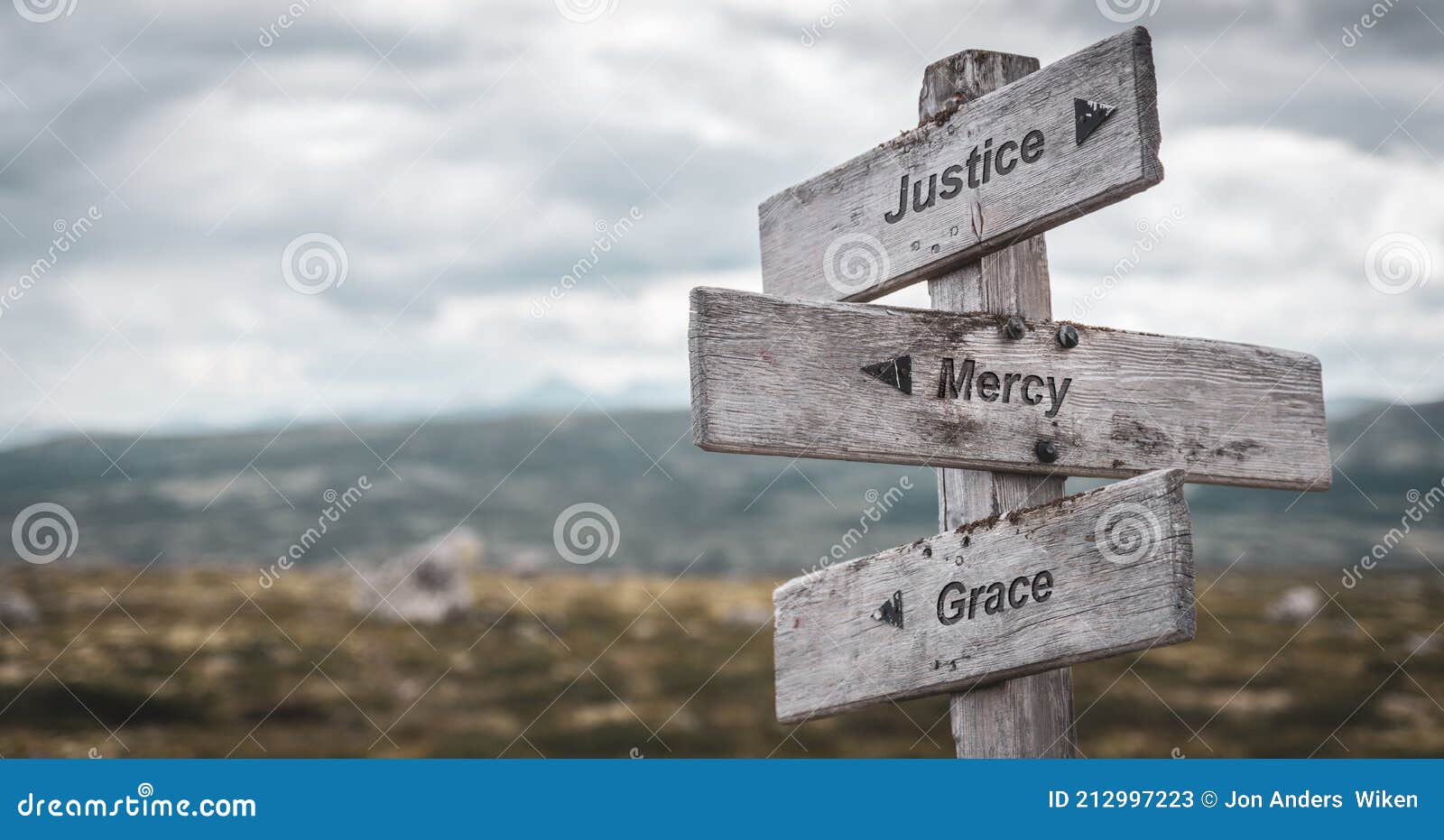 justice mercy grace text engraved on wooden signpost outdoors in nature.