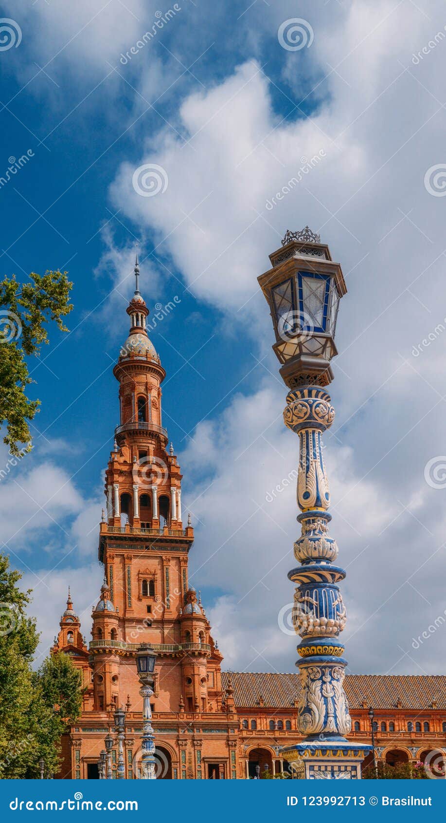 juxtaposition of blue and white ceramic azulejo tiles against one of the baroque sandstone tower at plaza de espana in seville, sp
