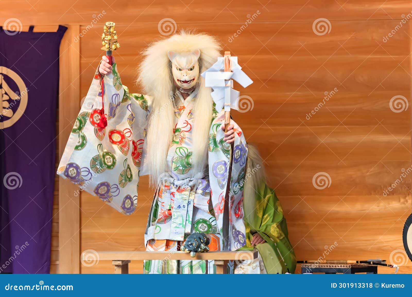 kagura dance performed by the inari fox deity holding suzu bells and a gohei wand.
