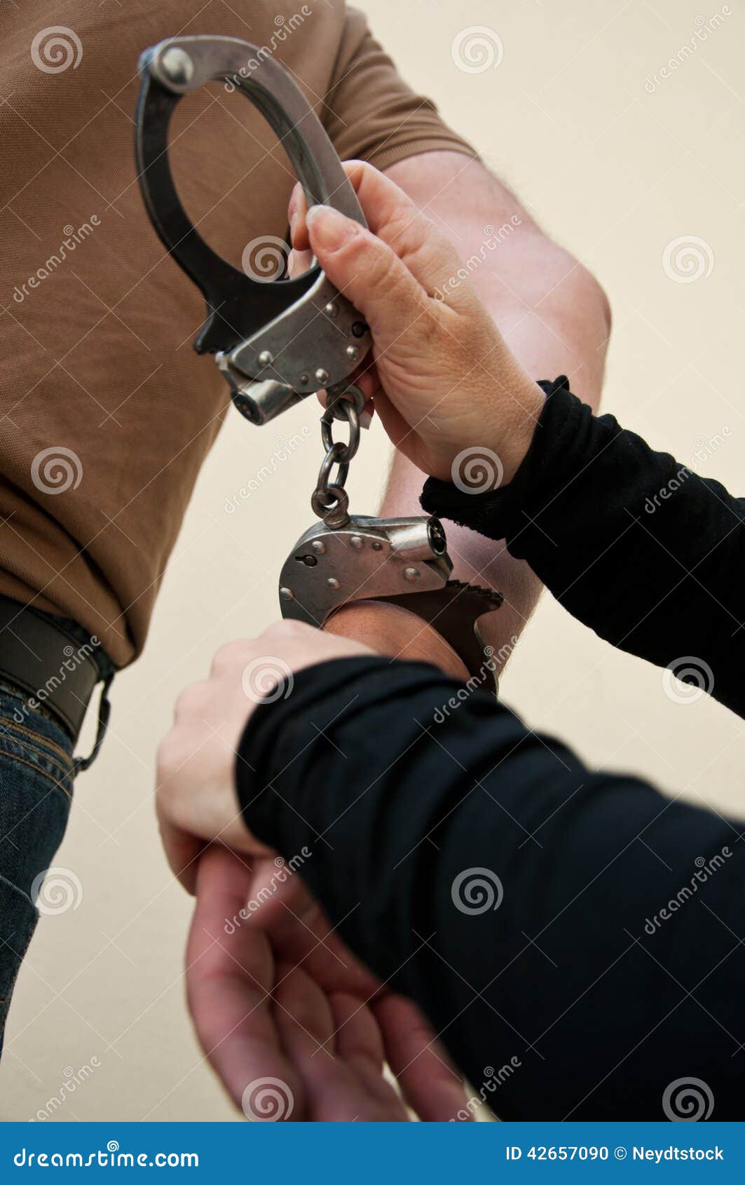 Парень надевает наручники. Мужчина в наручниках. Надевают наручники. Застегивают наручники. Преступник в наручниках.