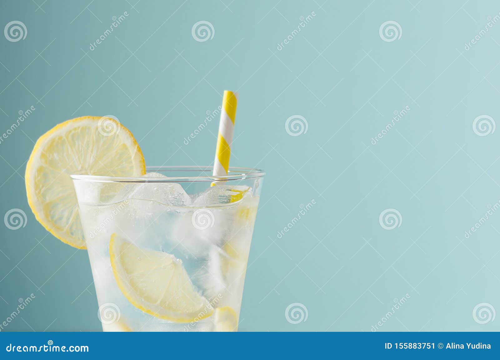 Kallrosa, uppfriskande dryck fÃ¶r fest med citronskivor, isbitar, toniskt, gult halm i elegant glas pÃ¥ mynta