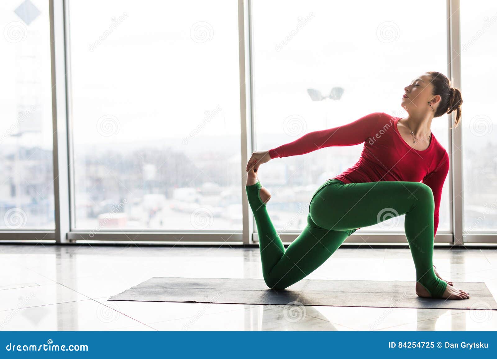 Beautiful yoga woman practice in a big window hall background