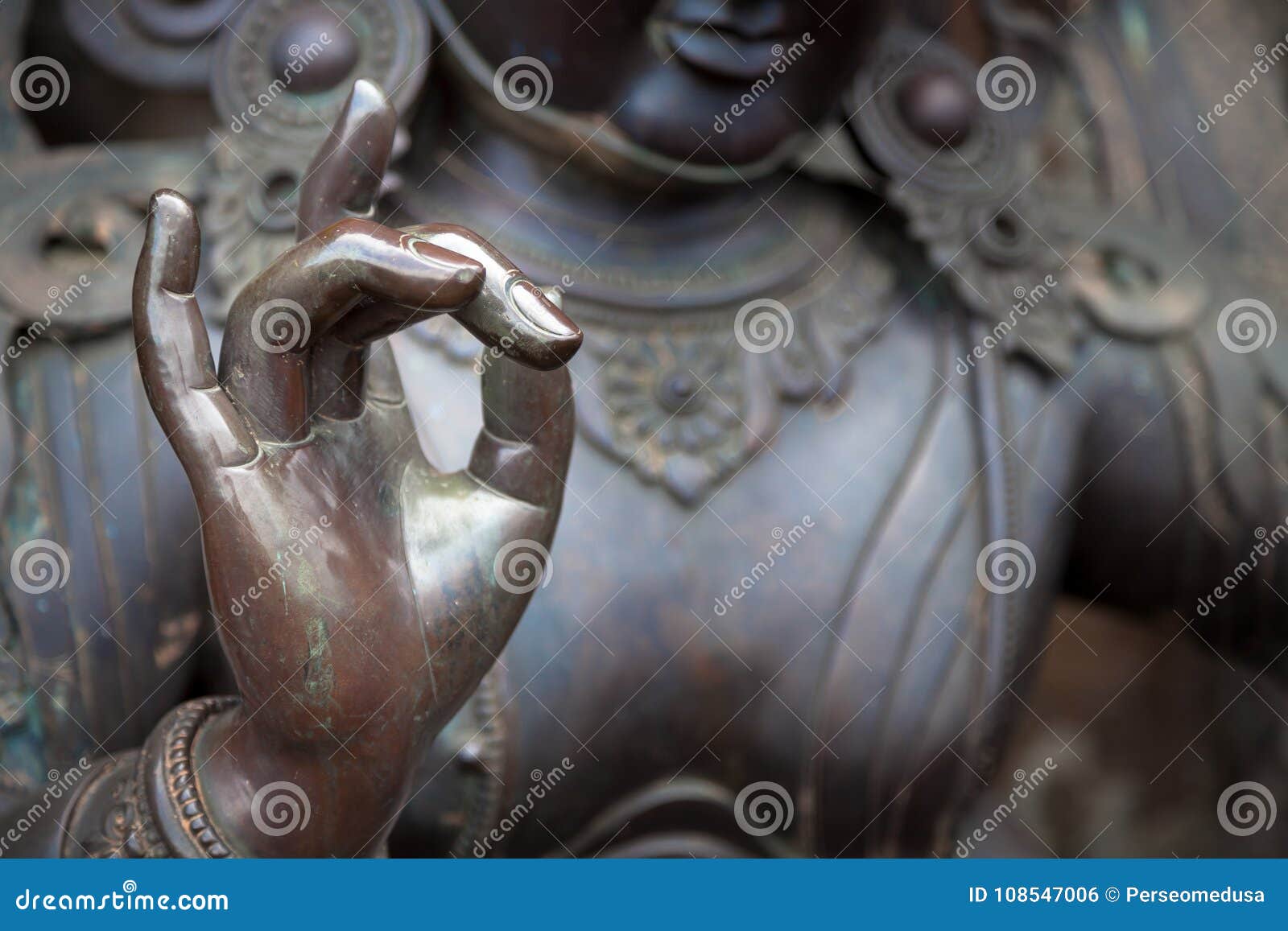 detail of buddha statue with karana mudra hand position