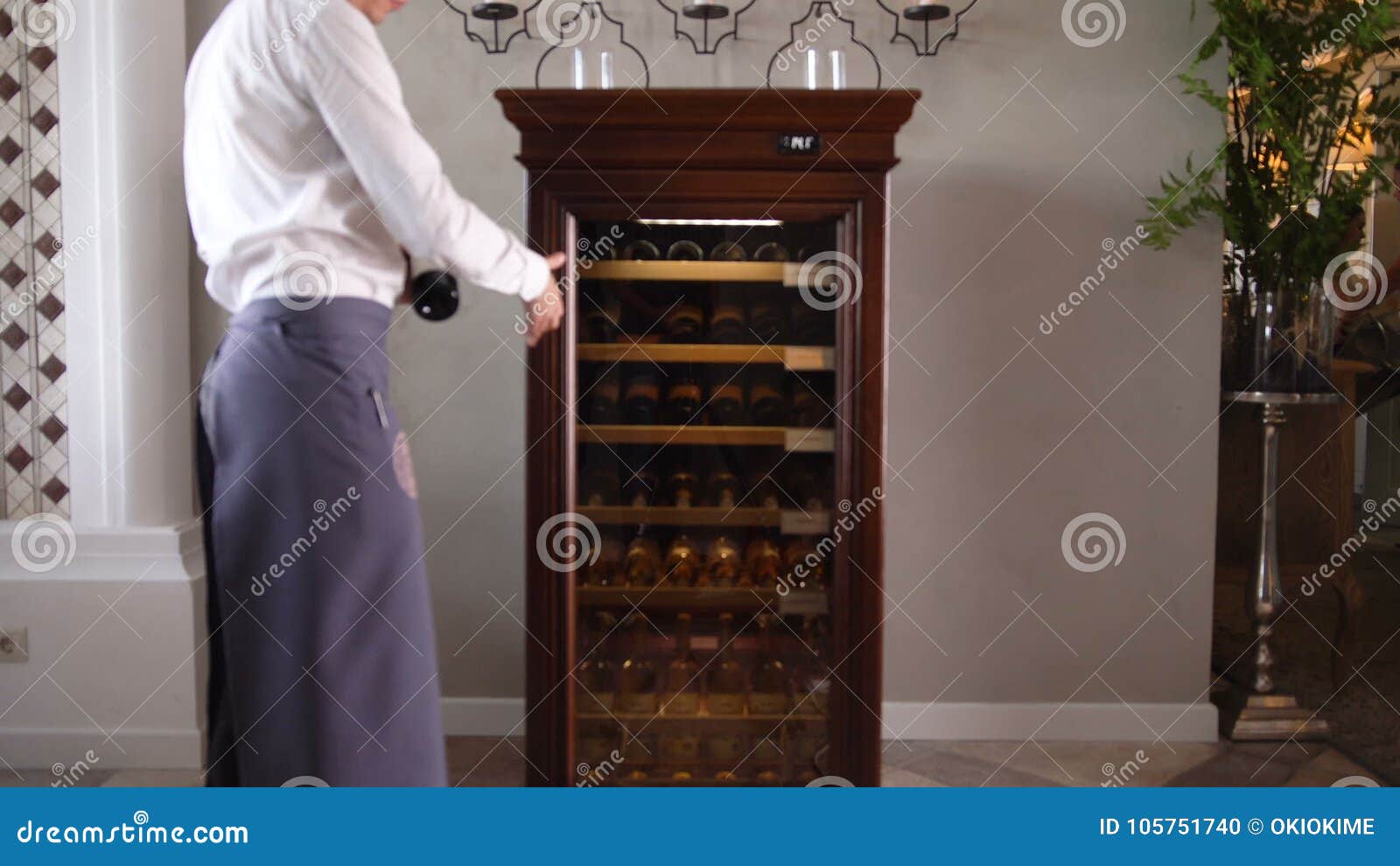 Camera Moves To Wine Cooling Cabinet And Waiter Takes Bottle Stock