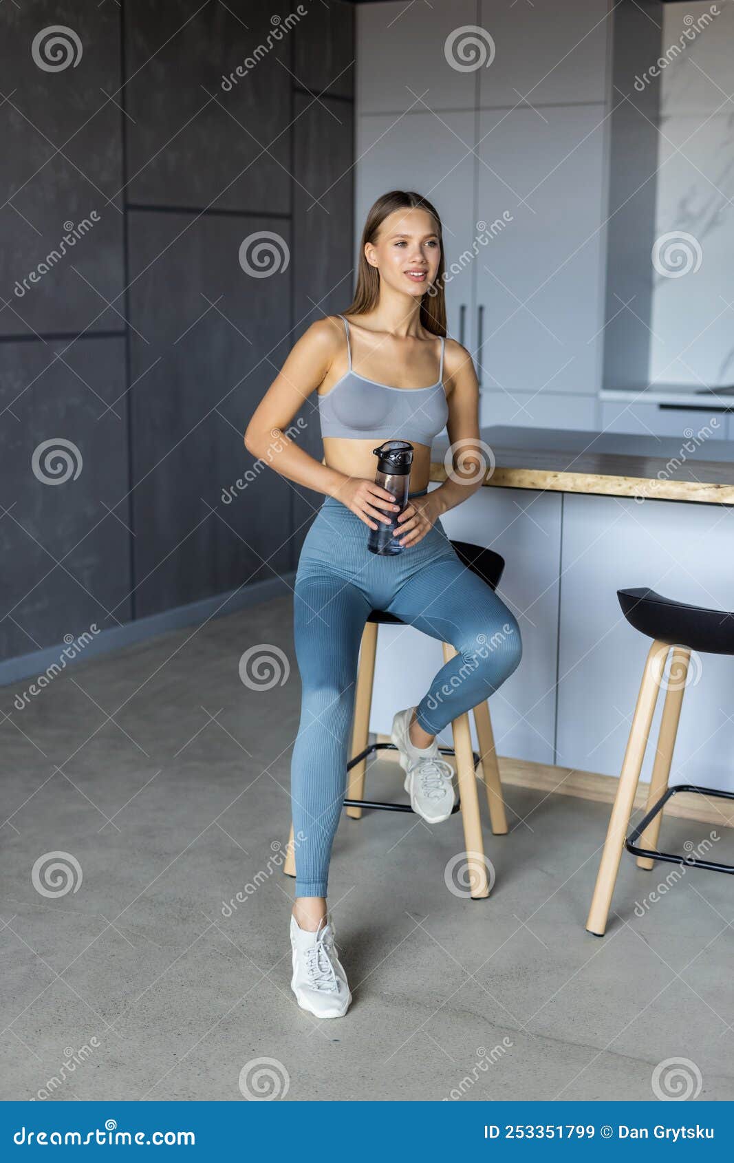 Keep hydrated. Young fit woman drinking water on yoga mat at home