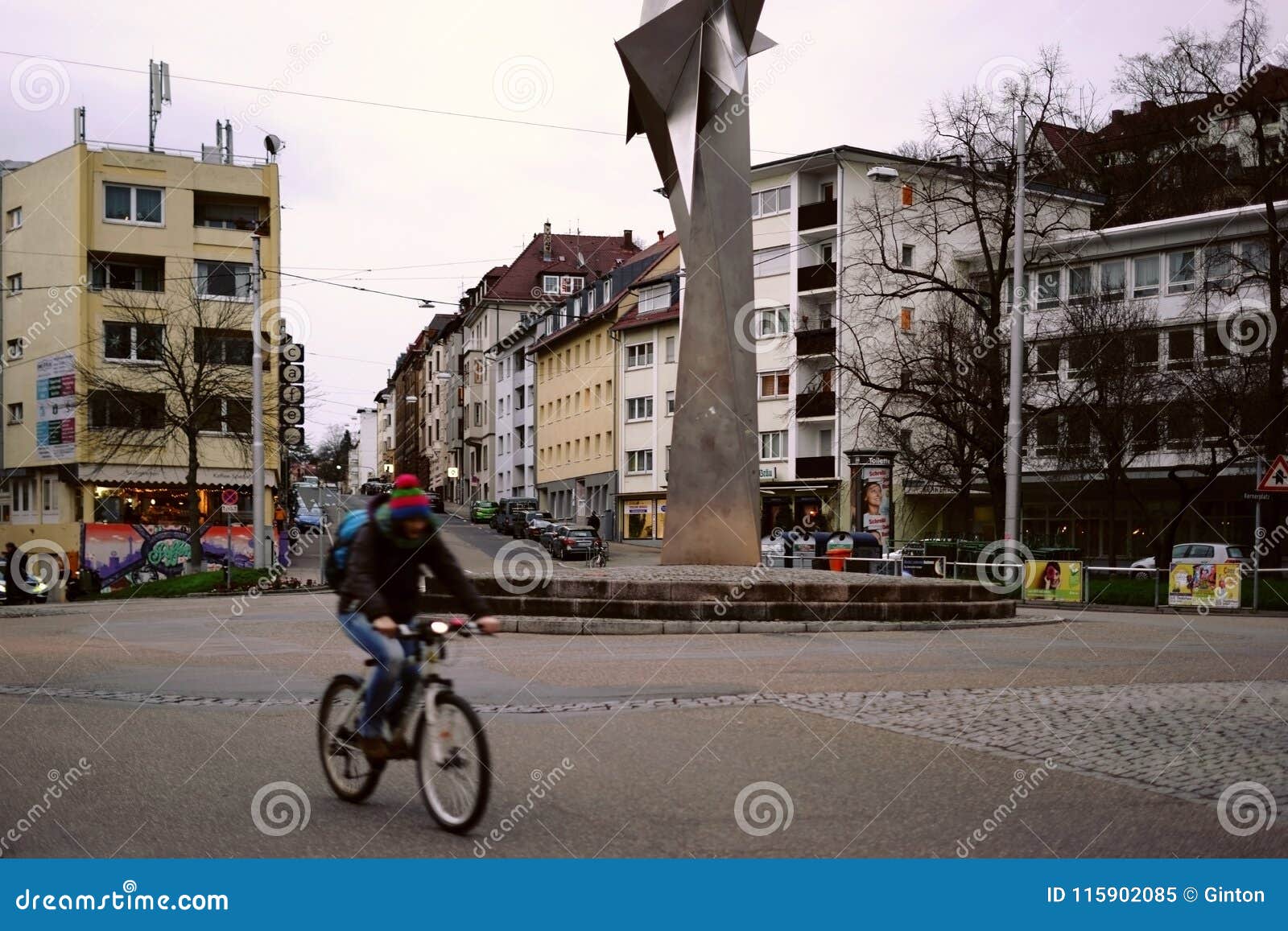 Kerner kwadrat Stuttgart. Stuttgart Niemcy, Luty, - 03, 2018: Cyklista krzyżuje Kerner kwadrat w wieczór z stali nierdzewnej rzeźbą 6-87/88 Erich Hauser na Luty 03, 2018 w Stuttgart