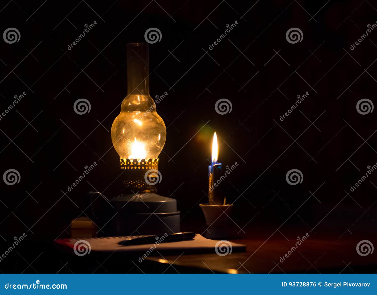 Kerosene Lamp Yellow Flame and a Candle Light Notebook with Pen Stock