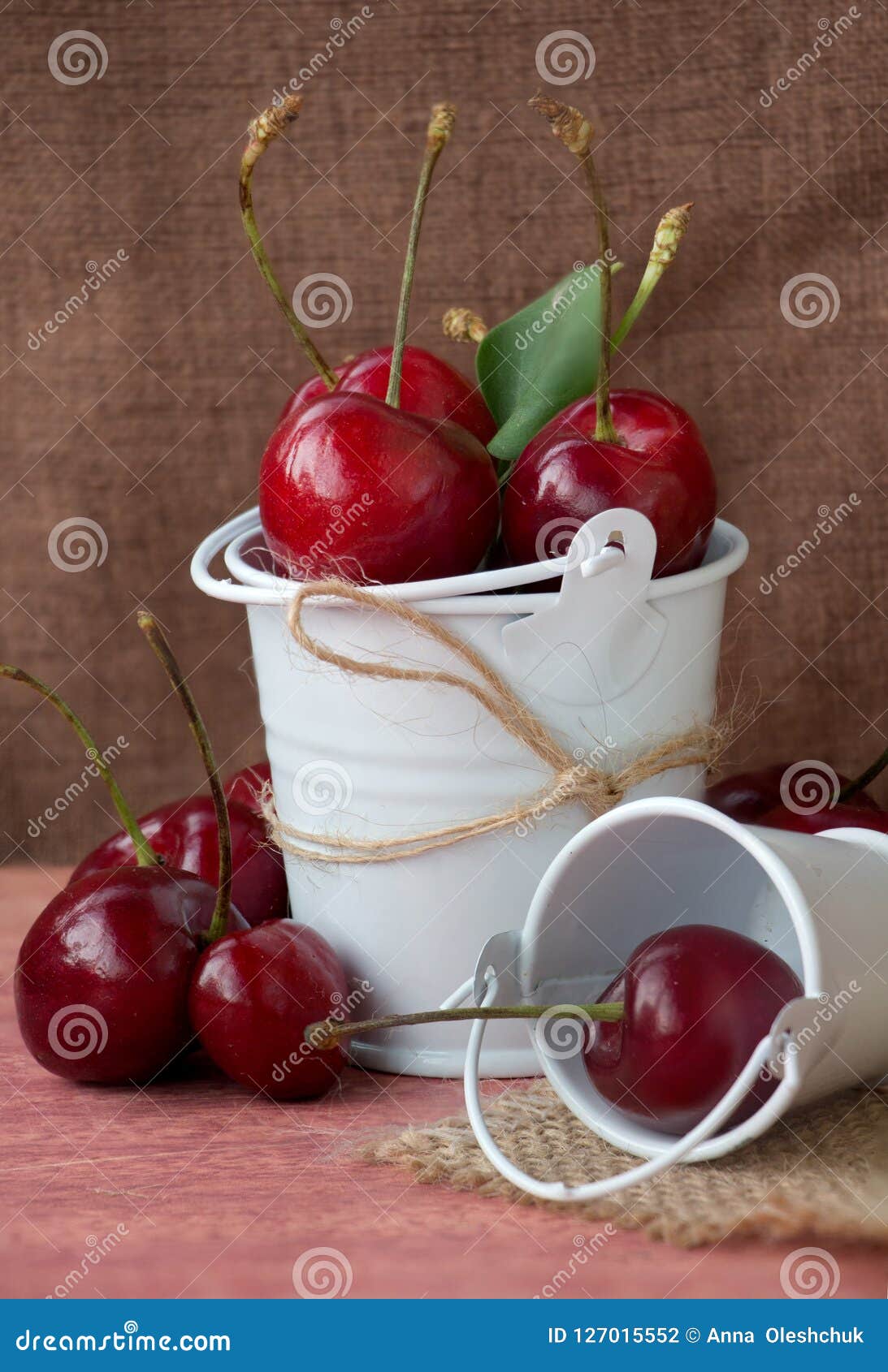 Kers in de emmer op de lijst. Stilleven van een kers in een emmer op een houten lijst Decoratief element