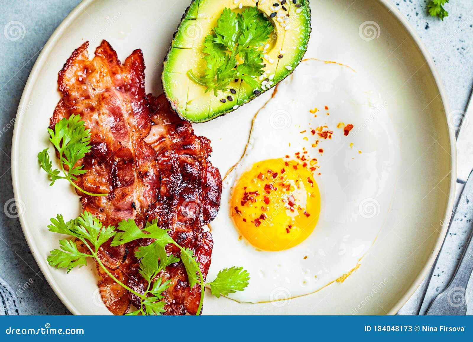 Keto Breakfast - Fried Egg, Avocado and Fried Bacon in White Plate