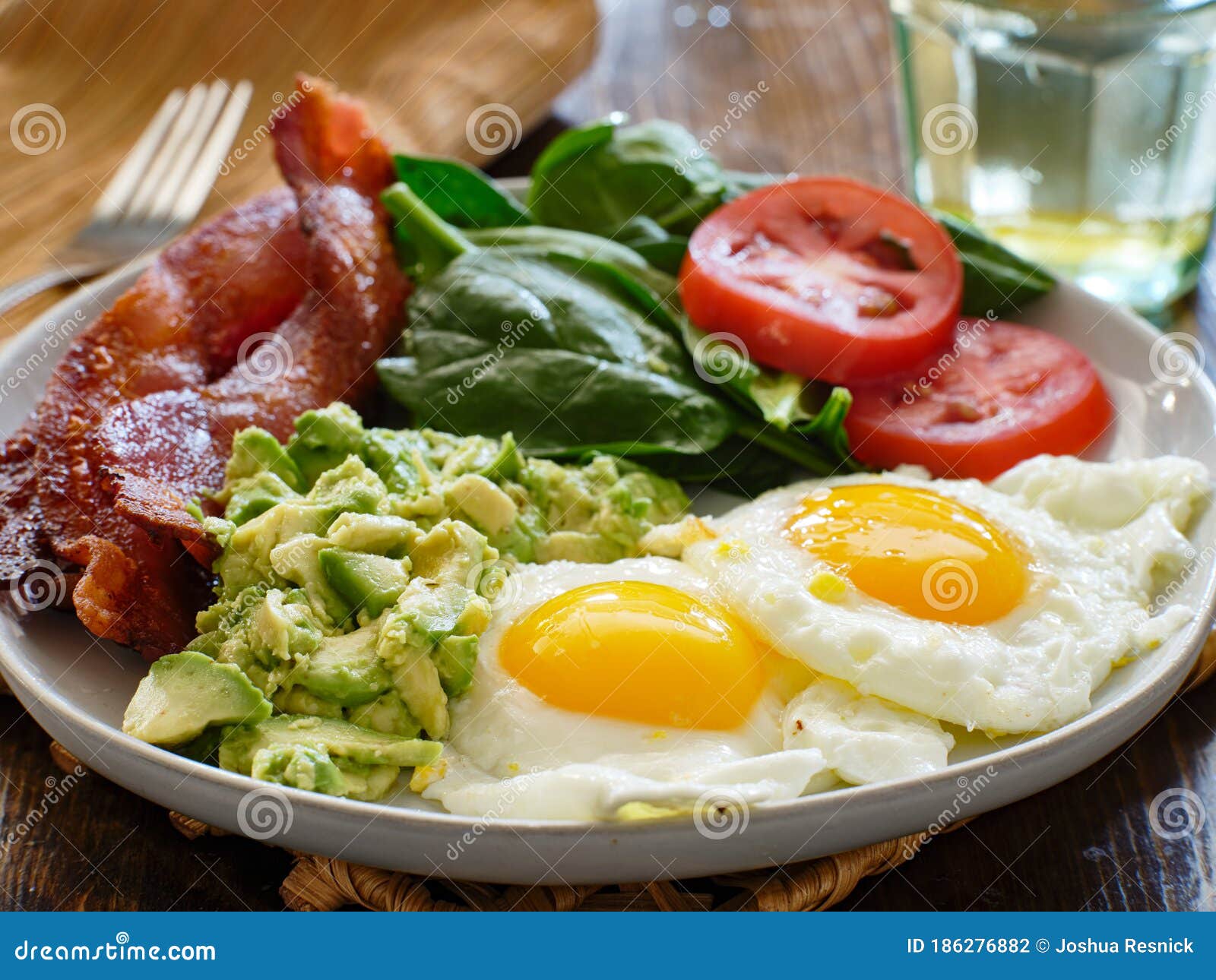Keto Breakfast Plate with Eggs Bacon and Mashed Avocado Stock Photo
