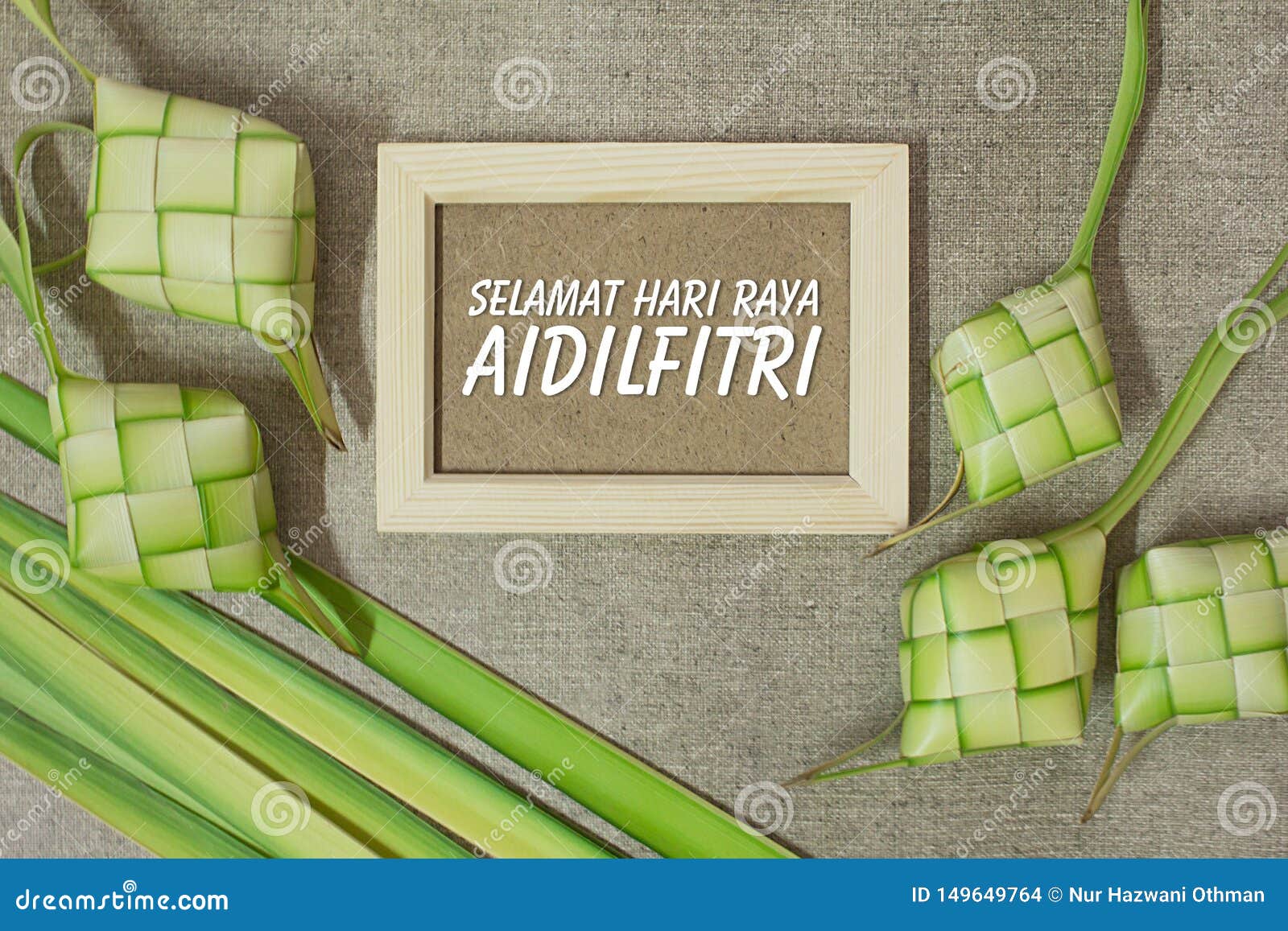 ketupat rice dumpling with the wording of selamat hari raya aidilfitri on jute texture background.