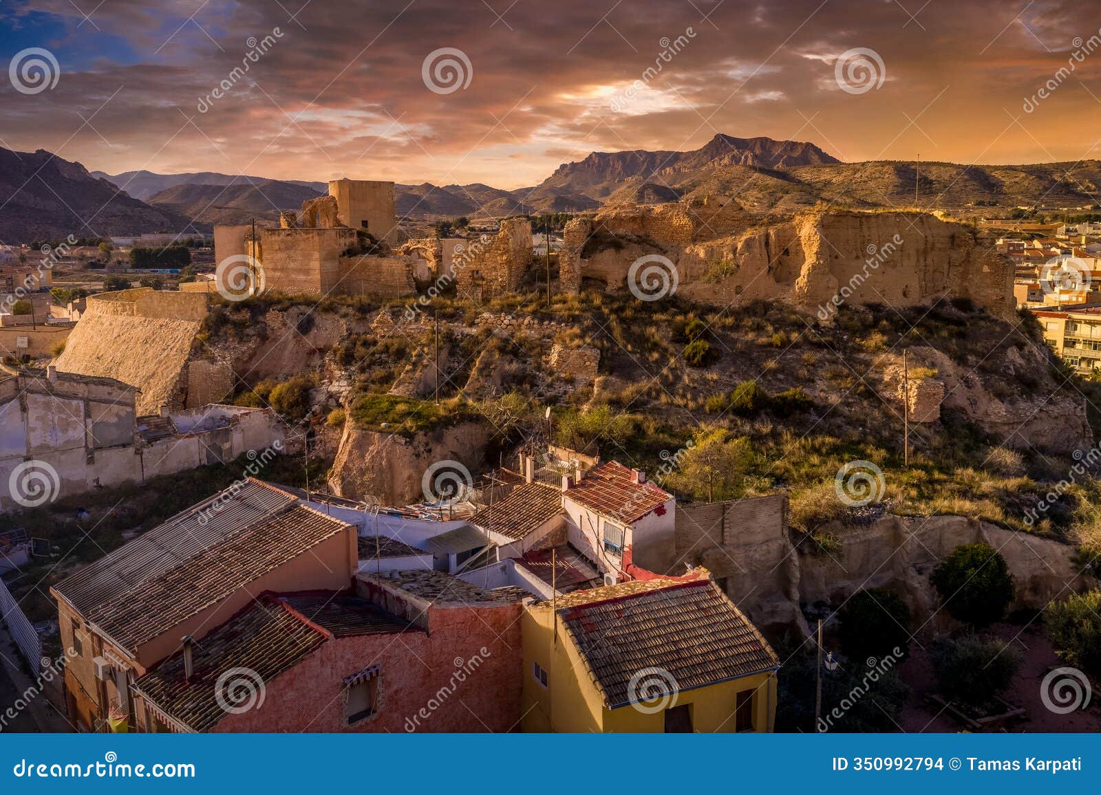 aerial view of newly restored elda castle in valencia province, white stone curtain wall, square and round tower spanish town