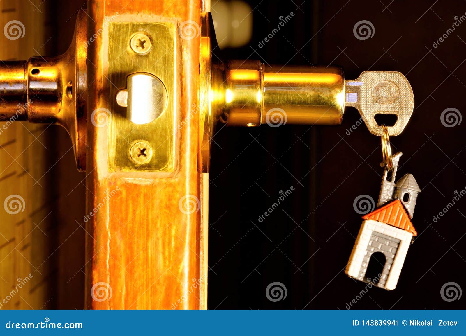 Key With A Keychain In The Form Of A House In The Door Lock The