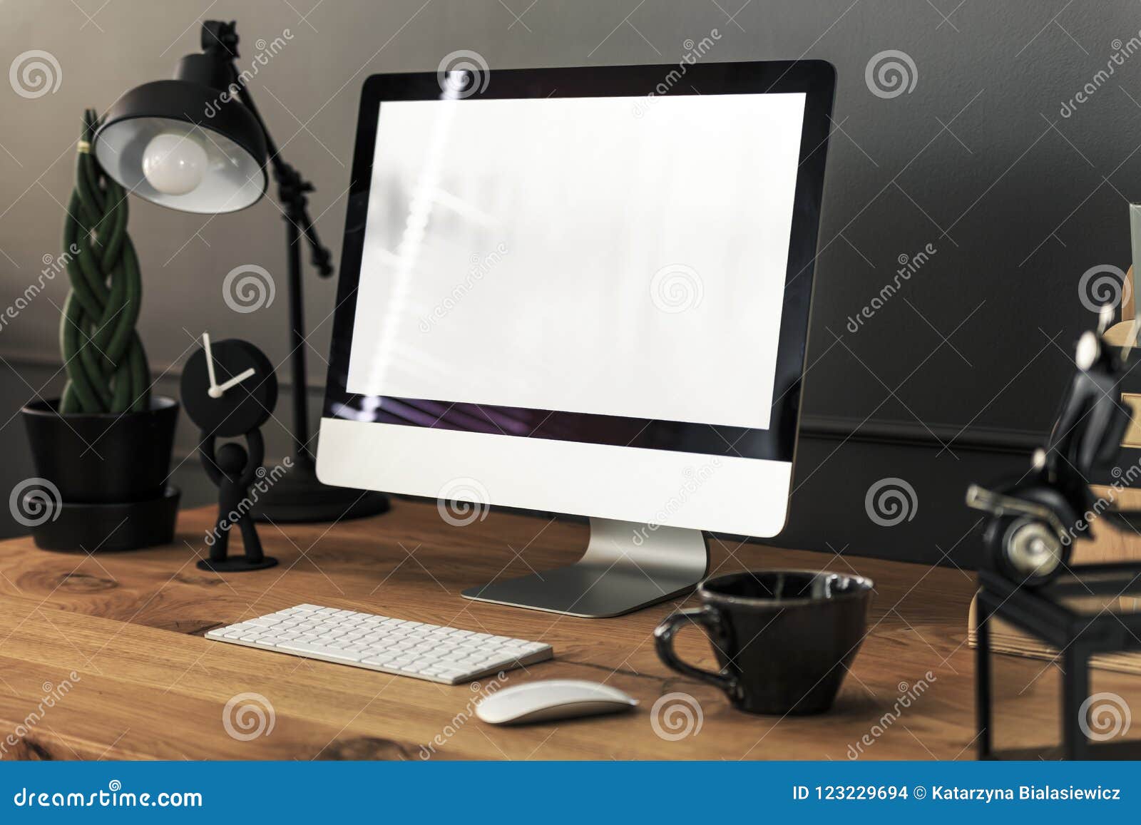 keyboard, mouse and desktop computer on wooden desk with lamp in