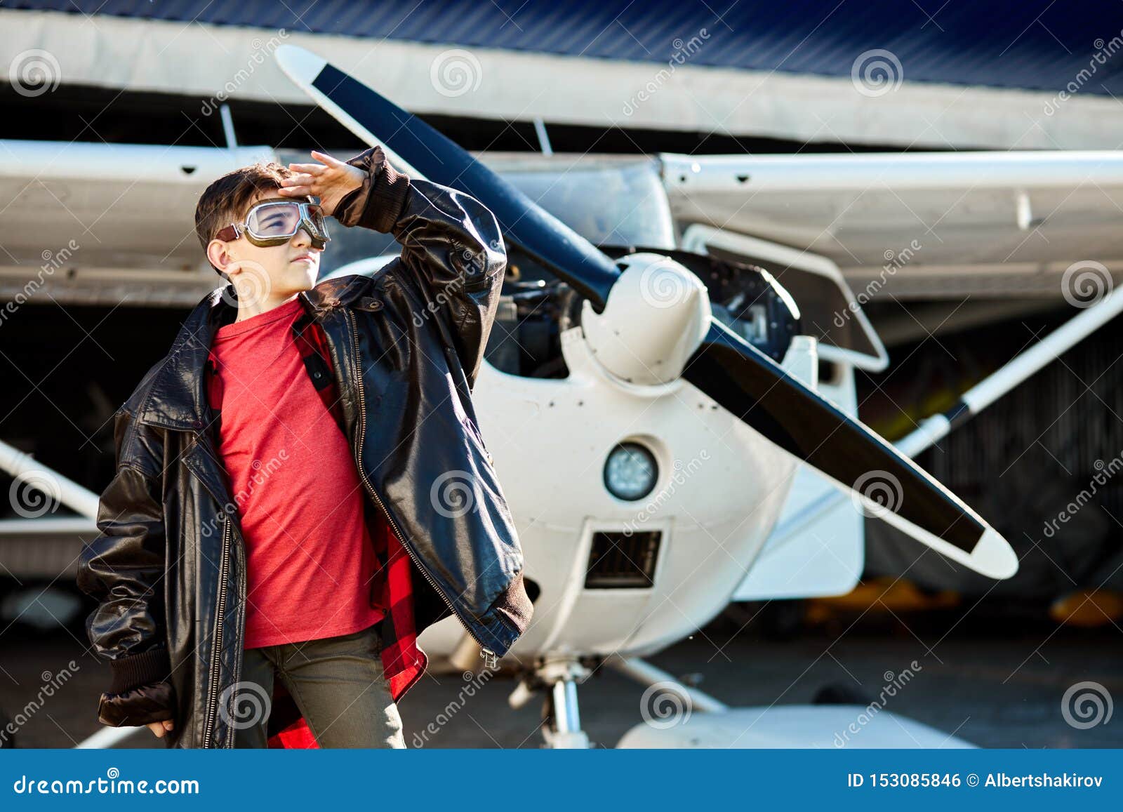 Kid in Aviator Glasses Stands in Front of White Singleengine Private
