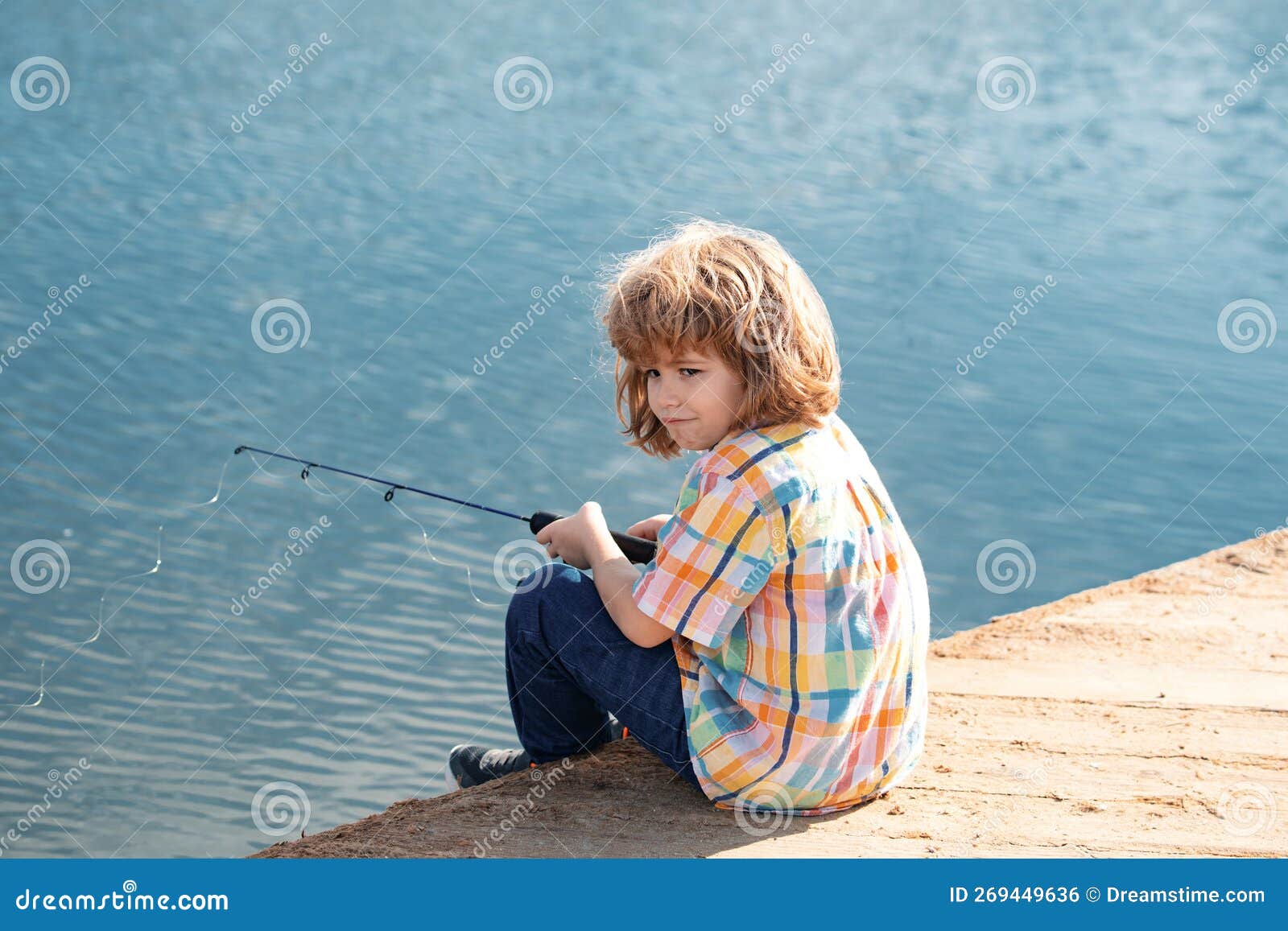 Kid Boy Fishing on the Lake. Young Fisher. Boy with Spinner at