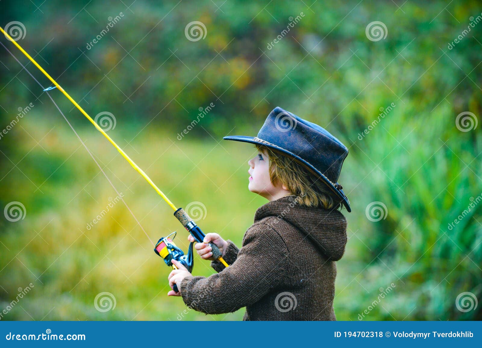 Kid with Fishing Rod at Lake. Little Boy Catching a Fish Stock