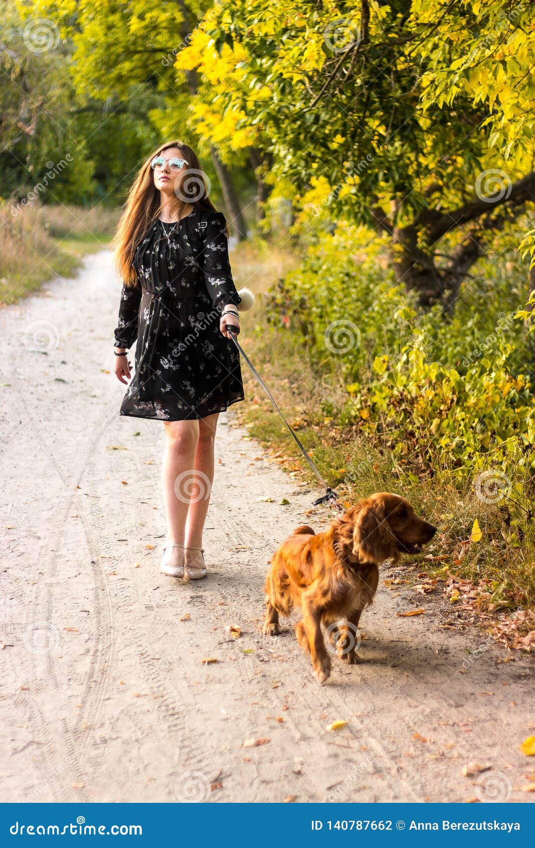 kid girl in dress running with the dog in the countryside at susnset