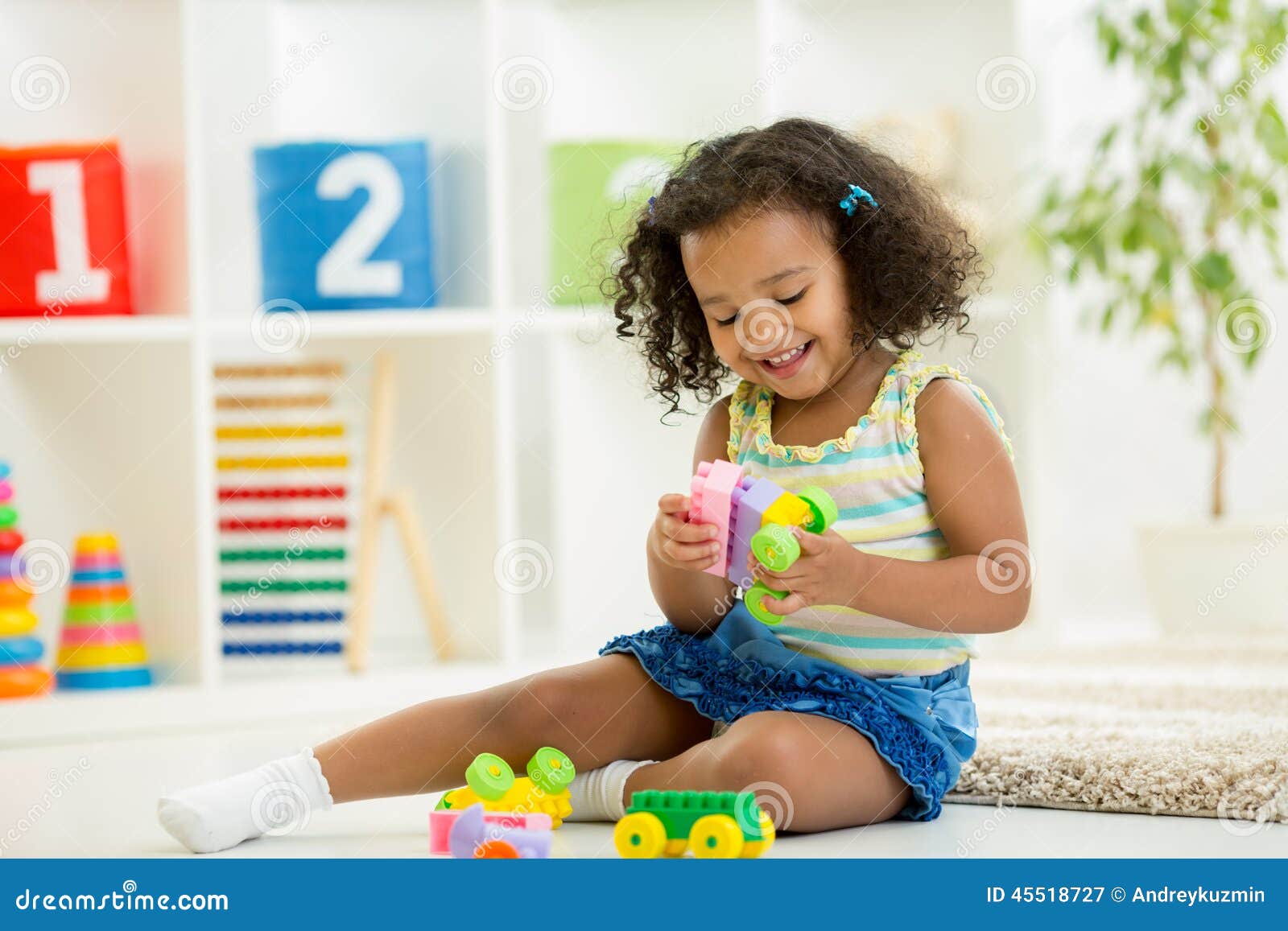 kid girl playing toys at kindergarten room