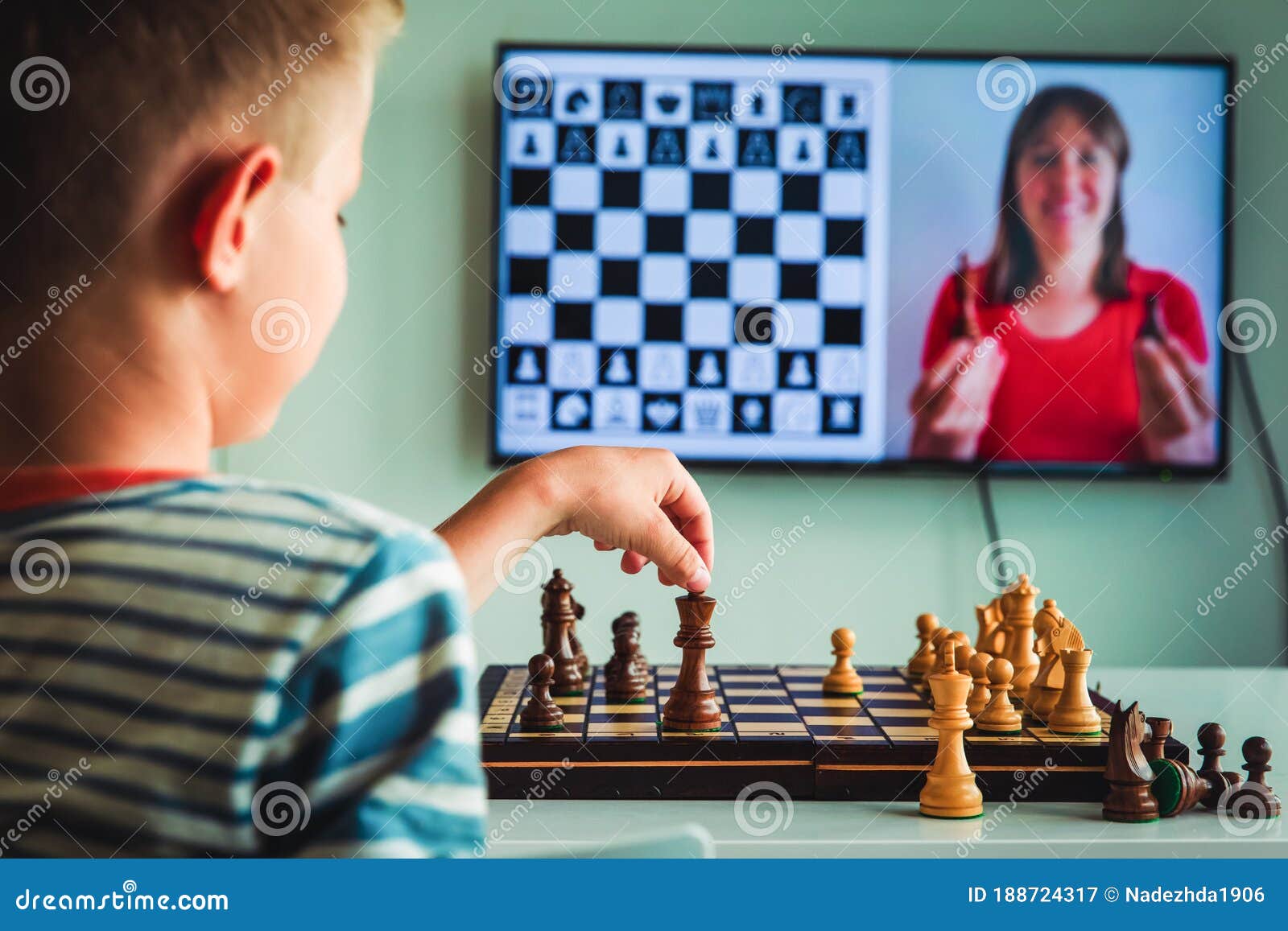 Teenage boy learning to play chess online with tablet computer