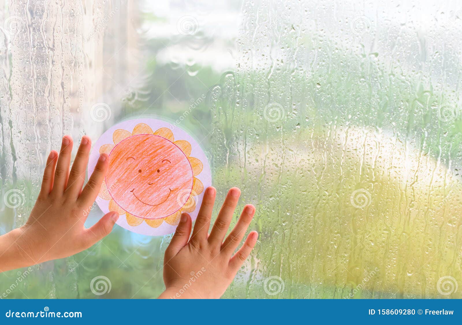 kid holding picture of smiling sun in a raining day concept of faith and optimism