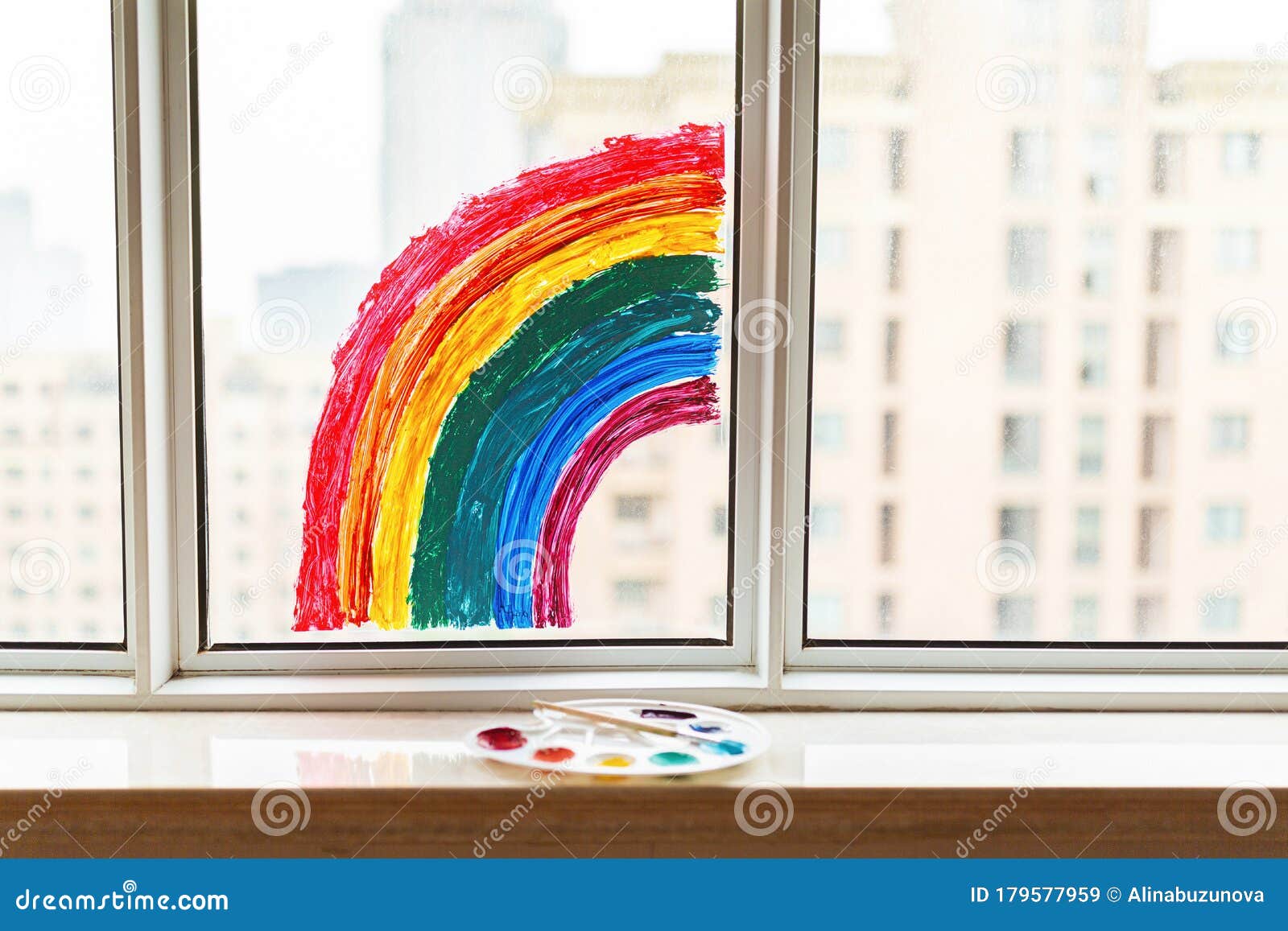 kid painted rainbow during covid-19 quarantine at home. girl near window. stay at home social media campaign for coronavirus