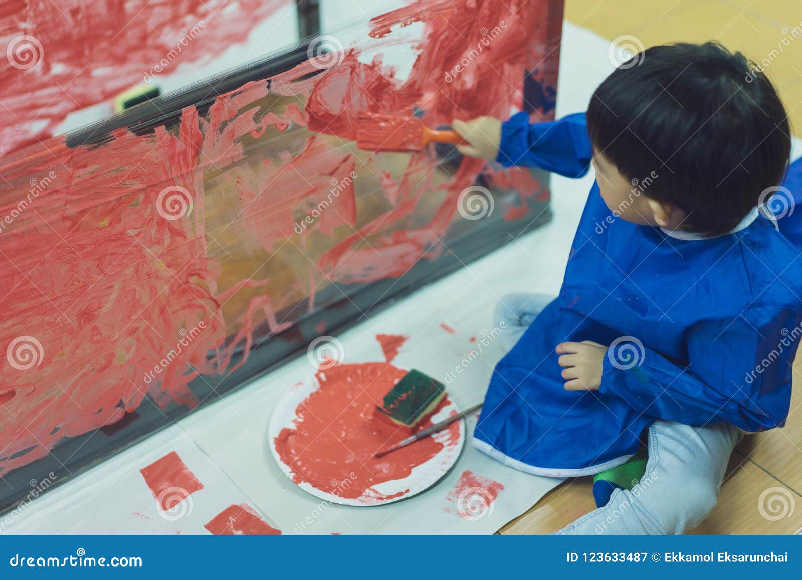 Kid is Painting the Plastic Wall with Red Color. Stock Image Image of face, elementary 123633487