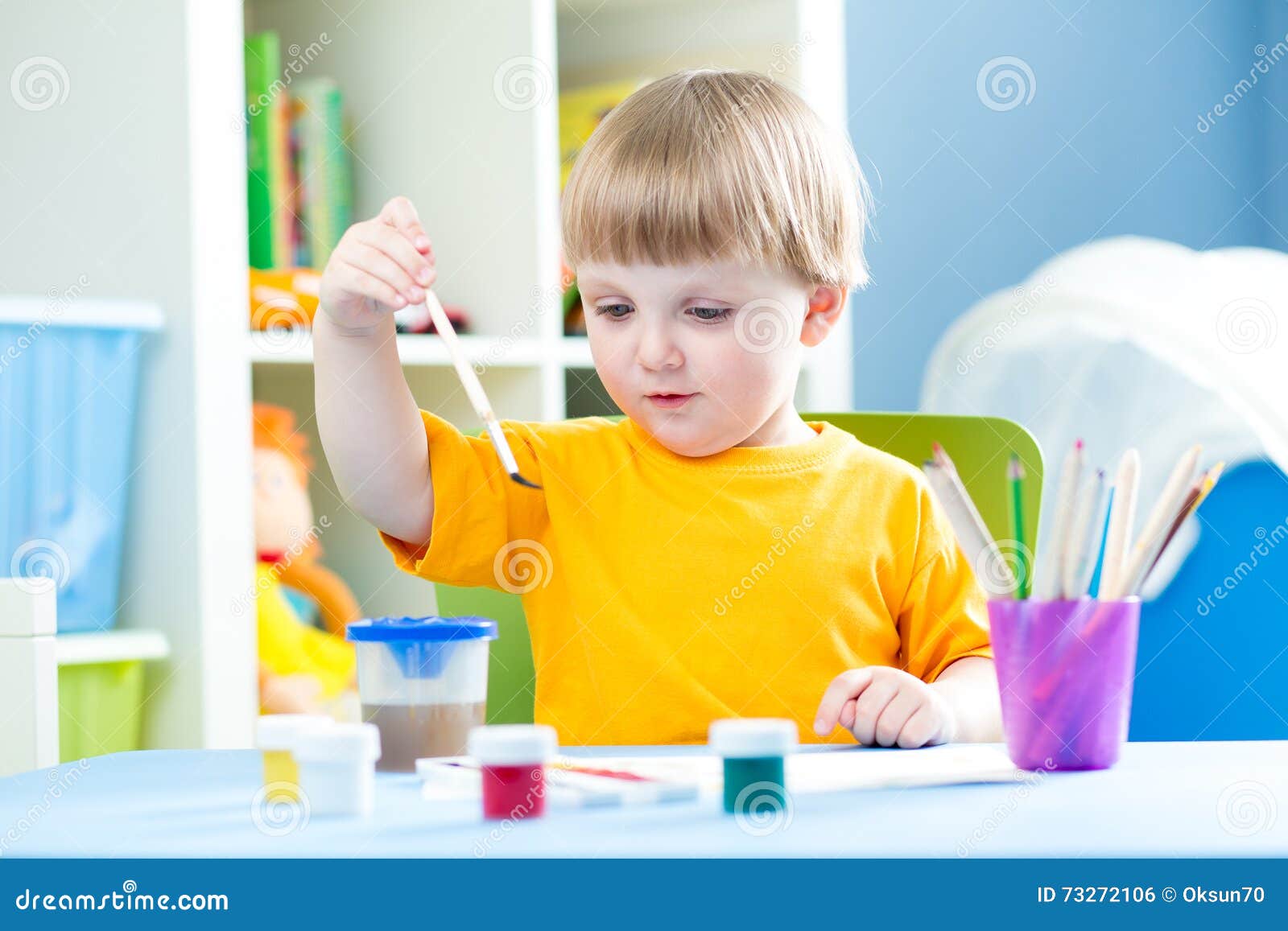 kid playing and painting at home or kindergarten or playschool