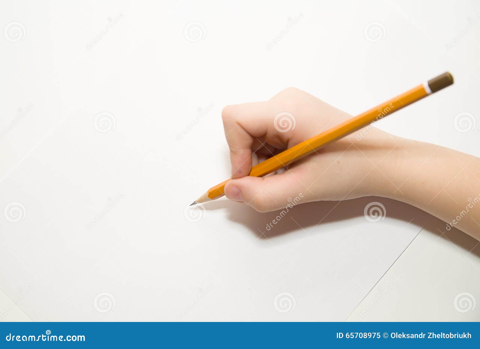 kid's right hand holding a pencil on over white