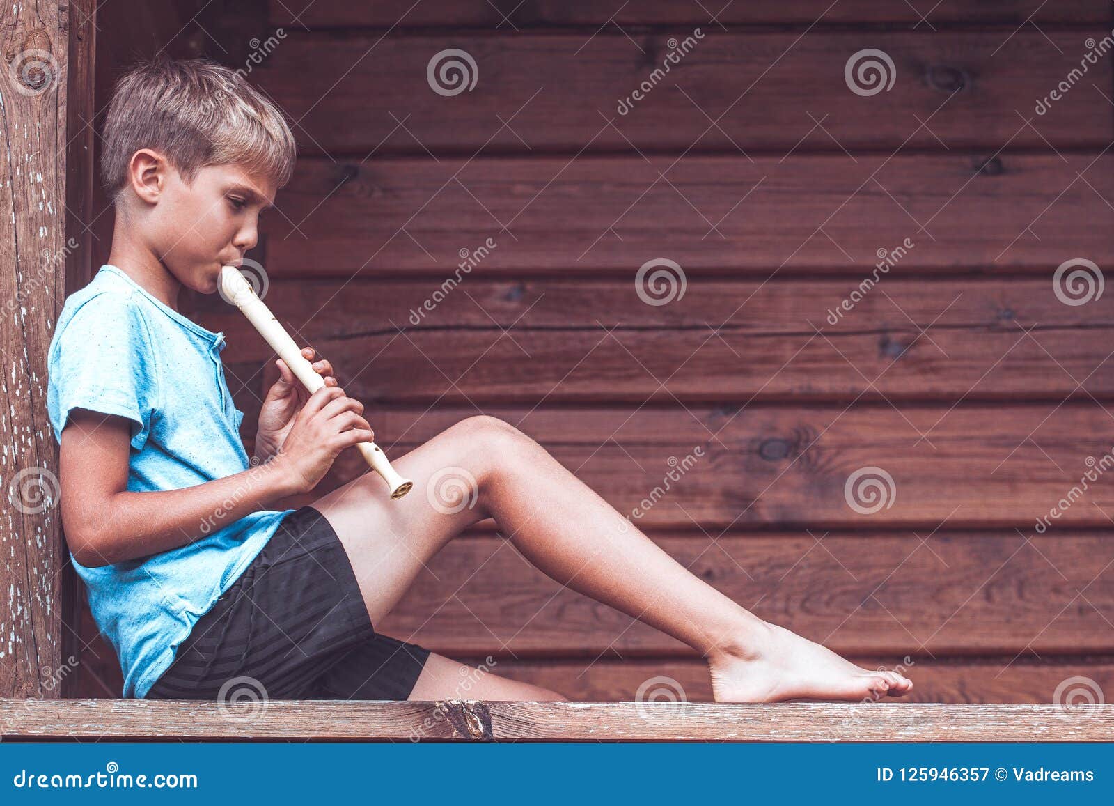 Boy Sitting on Terrace and Playing Flute Outdoors Stock Image Image